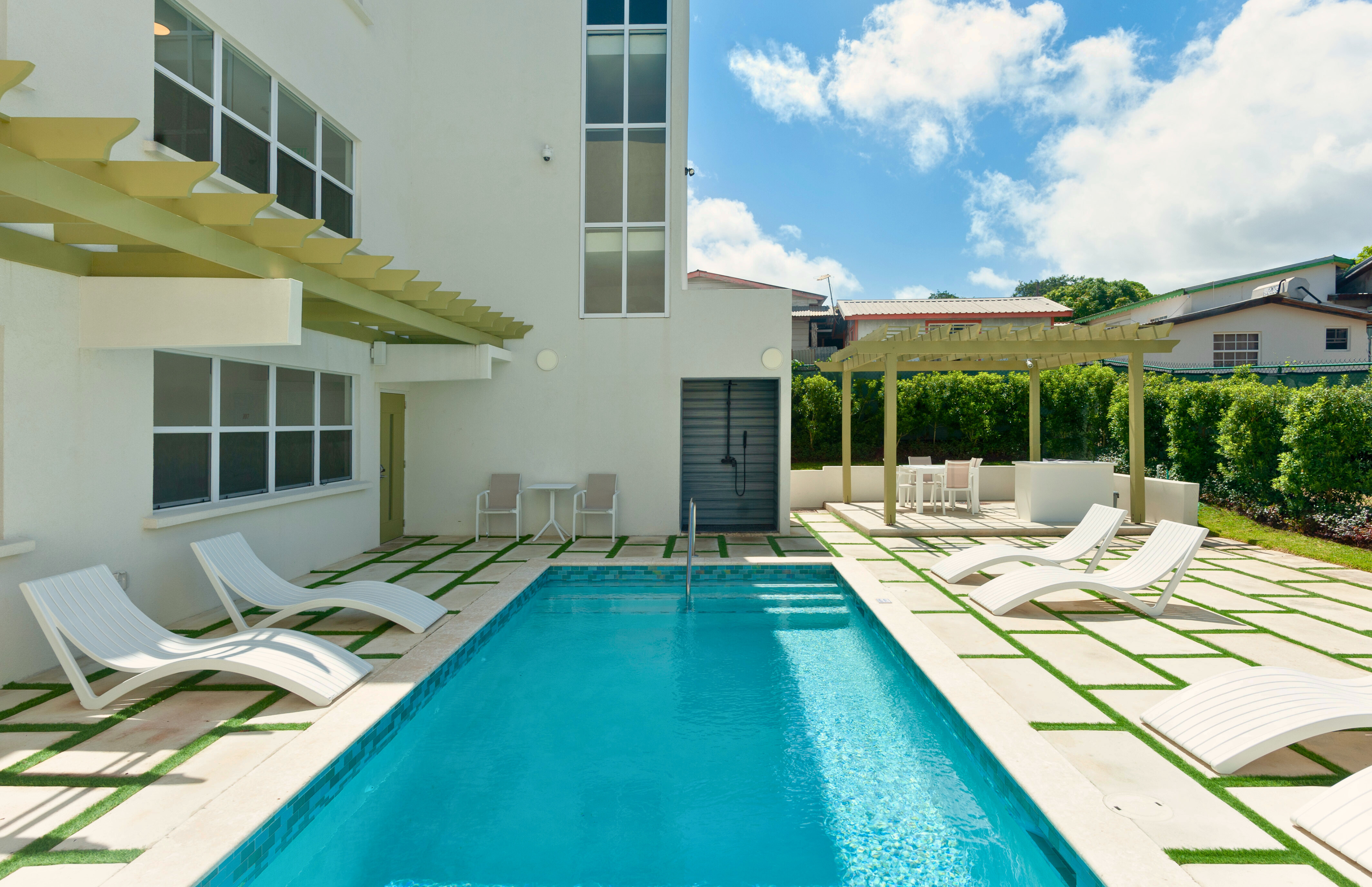 Modern private pool patio with loungers, pergola, and sunny resort-style vibes