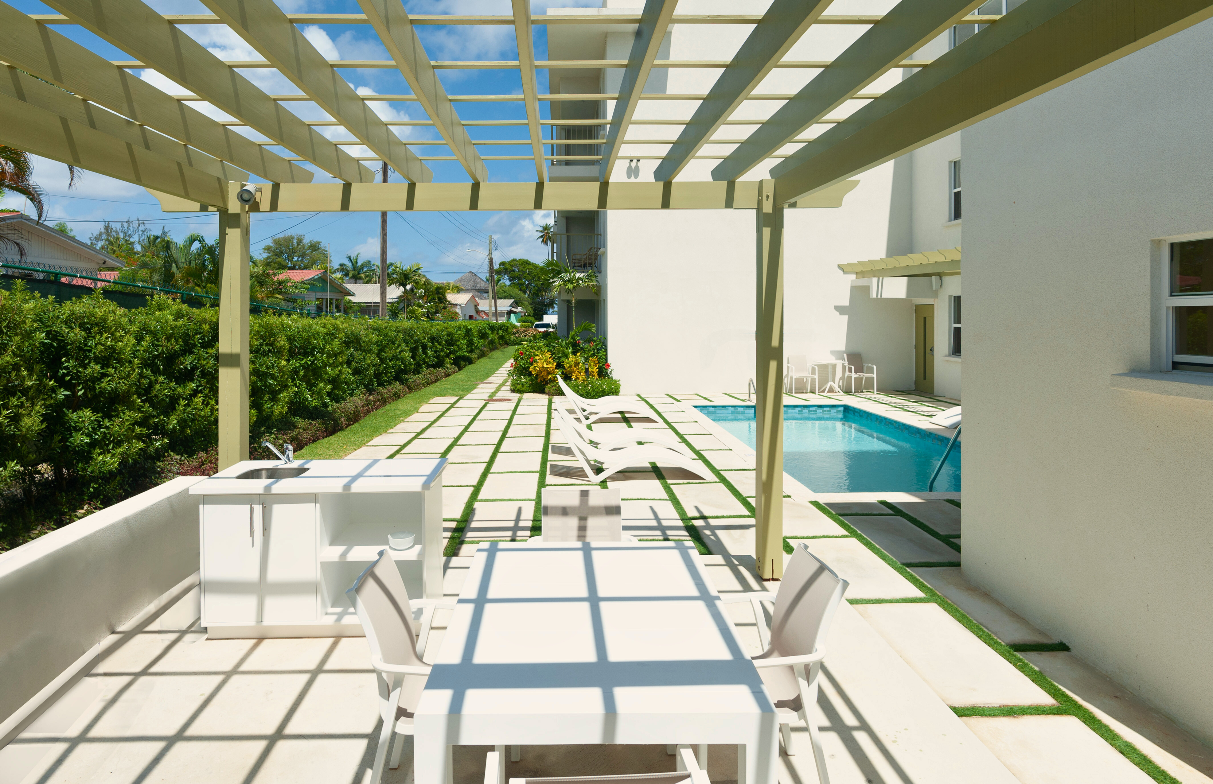 Modern pergola patio with private pool and chic resort-style loungers
