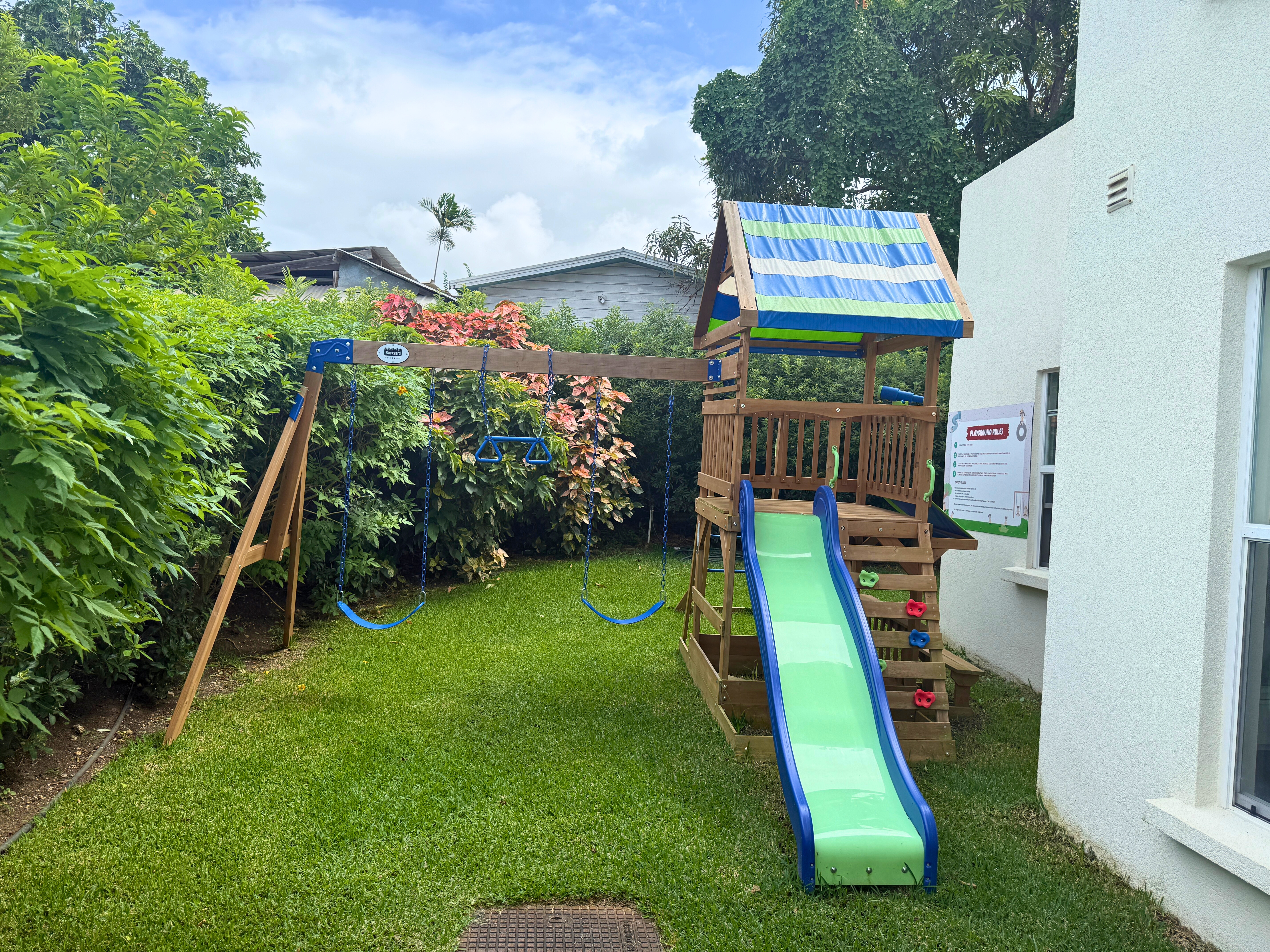 Family-friendly garden with playset, swings, and slide