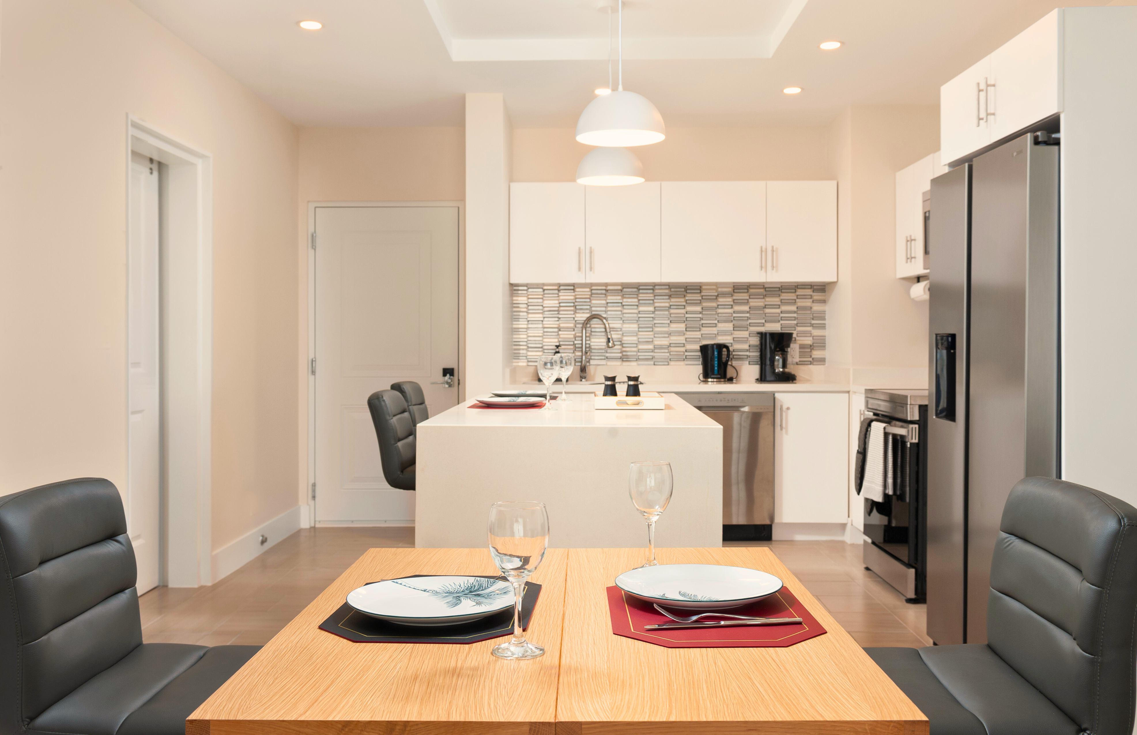 Bright modern kitchen with island, dining for two, and stainless appliances