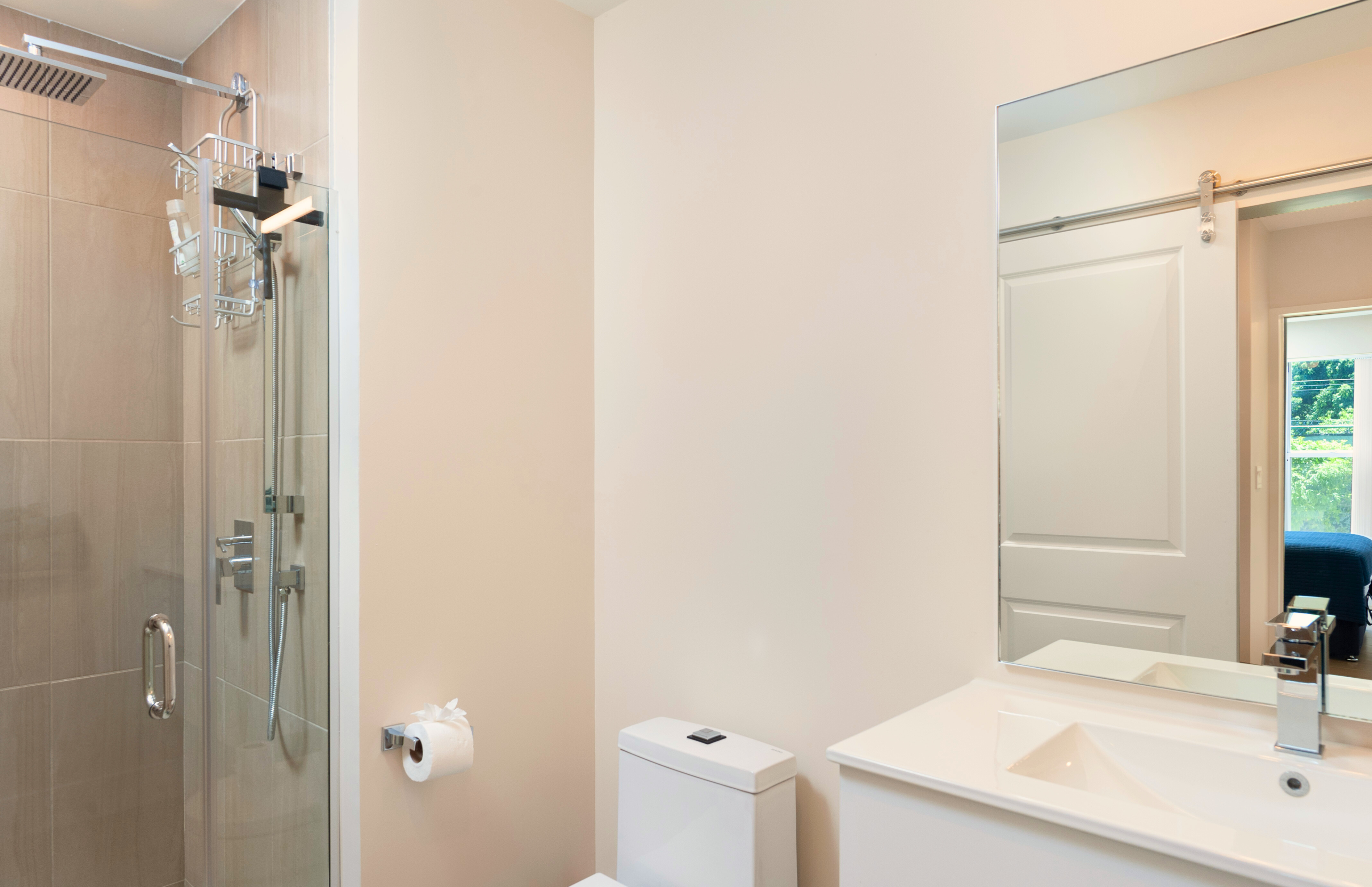 Bright modern bathroom with glass shower and sleek vanity