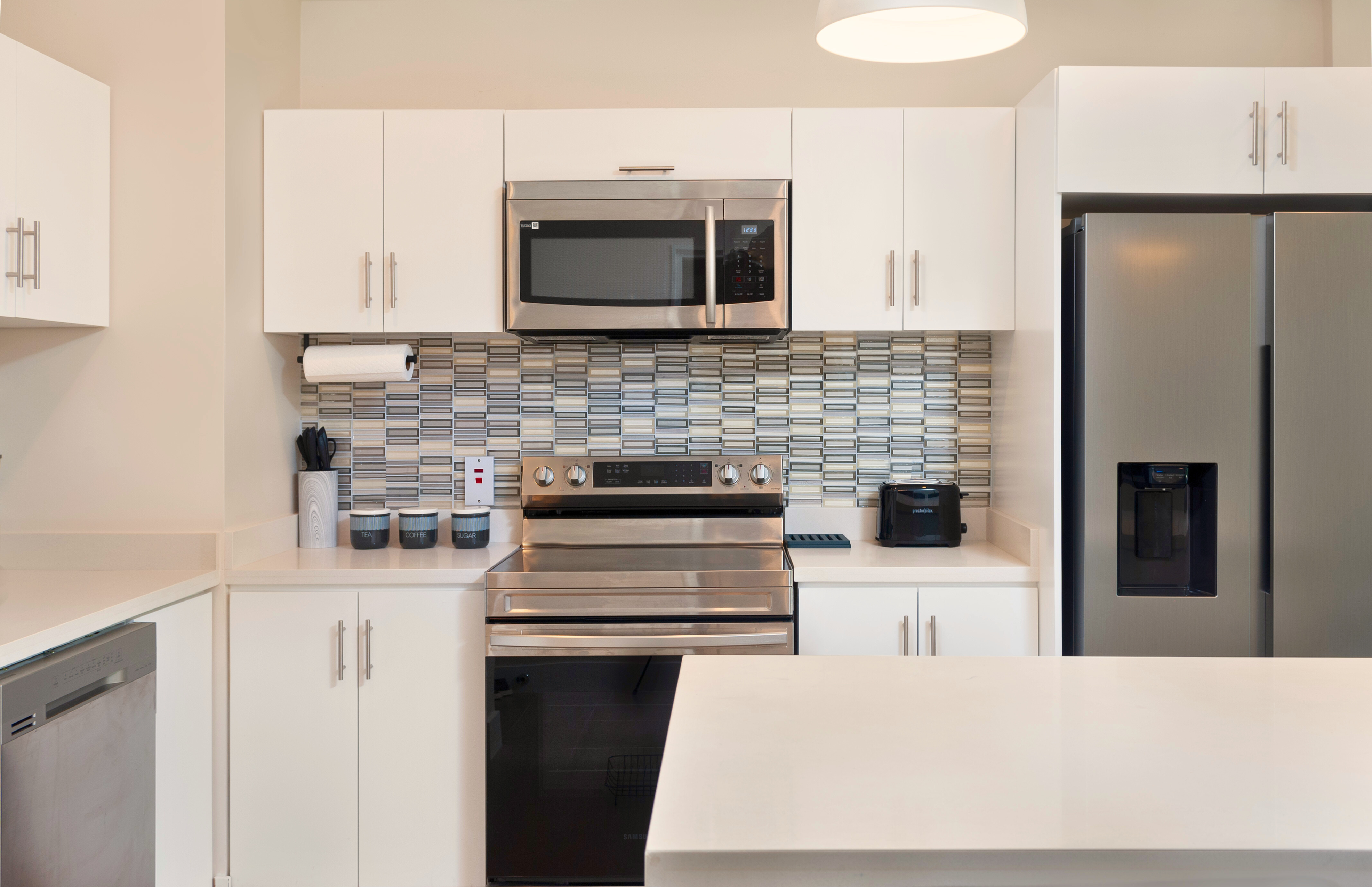 Bright modern kitchen with island, stainless appliances, and stylish finishes