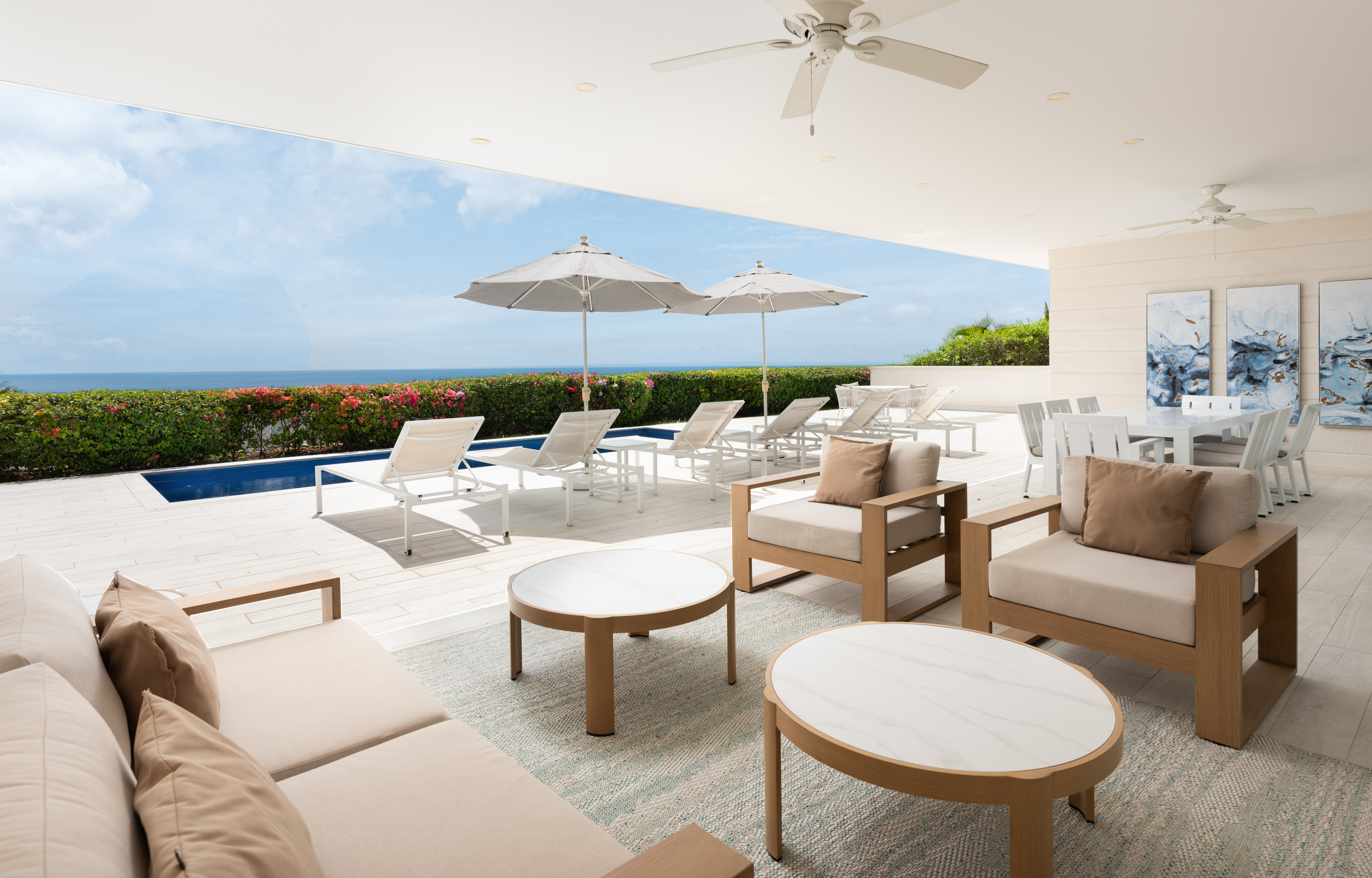 Covered oceanview patio with poolside loungers and elegant outdoor seating