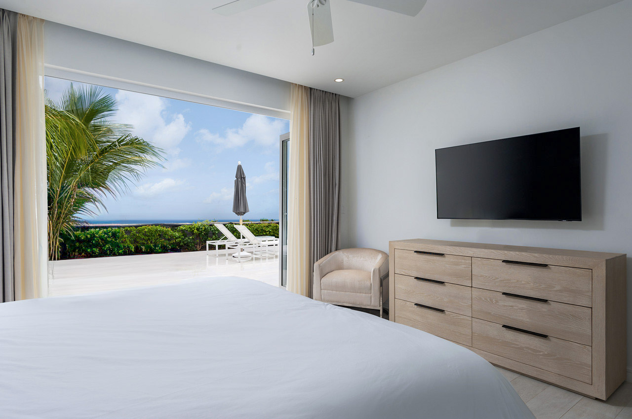 Modern oceanview bedroom with private terrace and tropical scenery