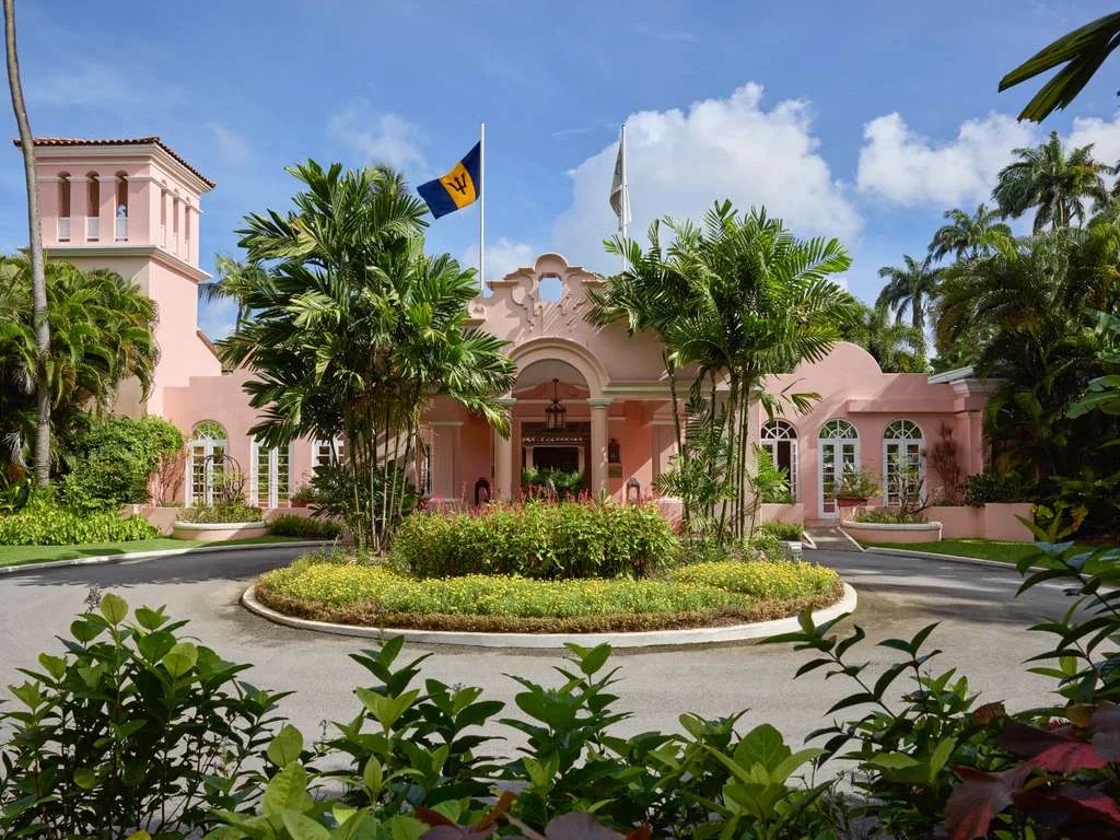 Elegant tropical entrance with lush gardens and grand pink Caribbean charm