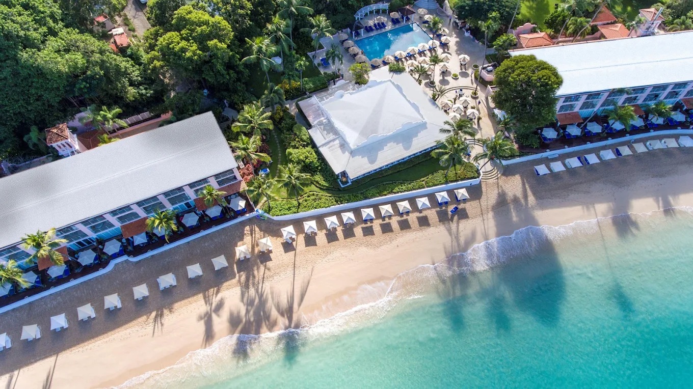 Beachfront resort with pool, palms, and direct access to turquoise water
