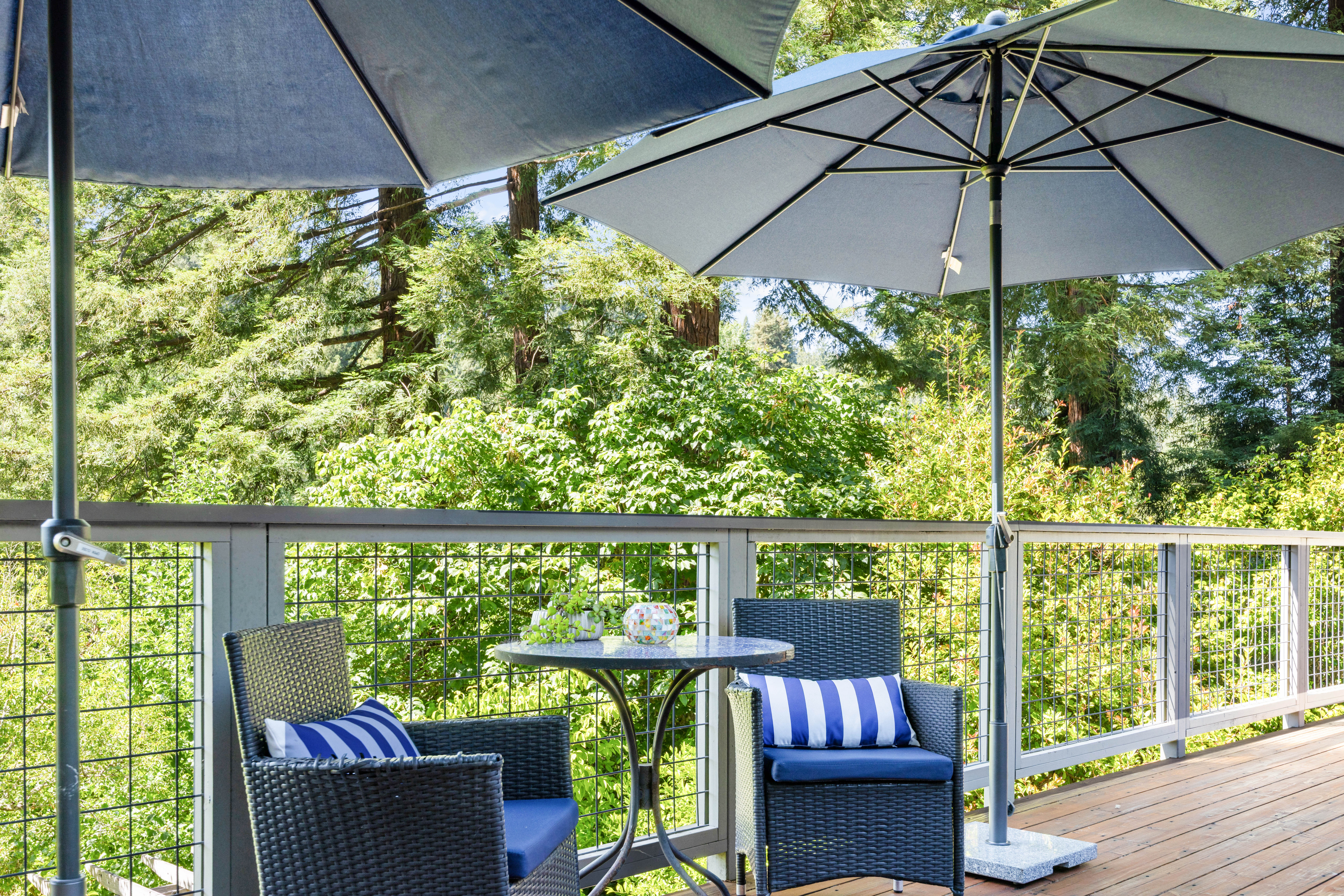 Shaded private deck with bistro seating in a peaceful forest setting
