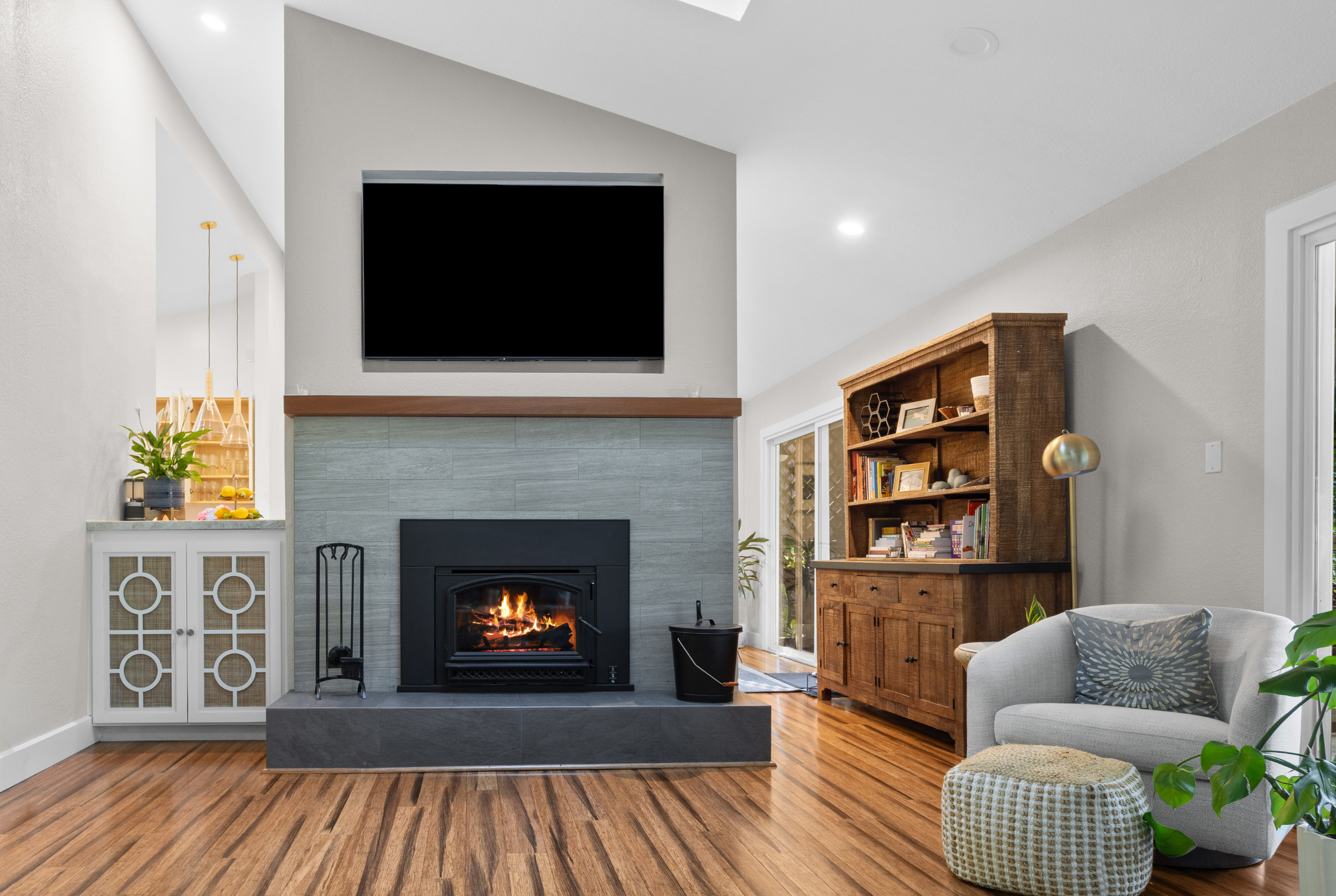 Vaulted living room with fireplace, big-screen TV, and cozy seating