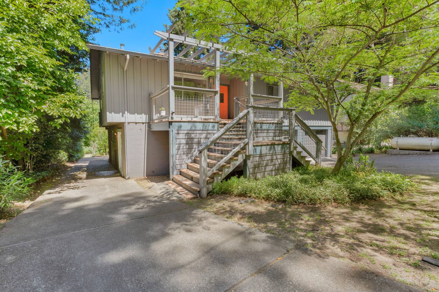 Surrounded by lush greenery and towering trees, the home offers a private and tranquil setting.