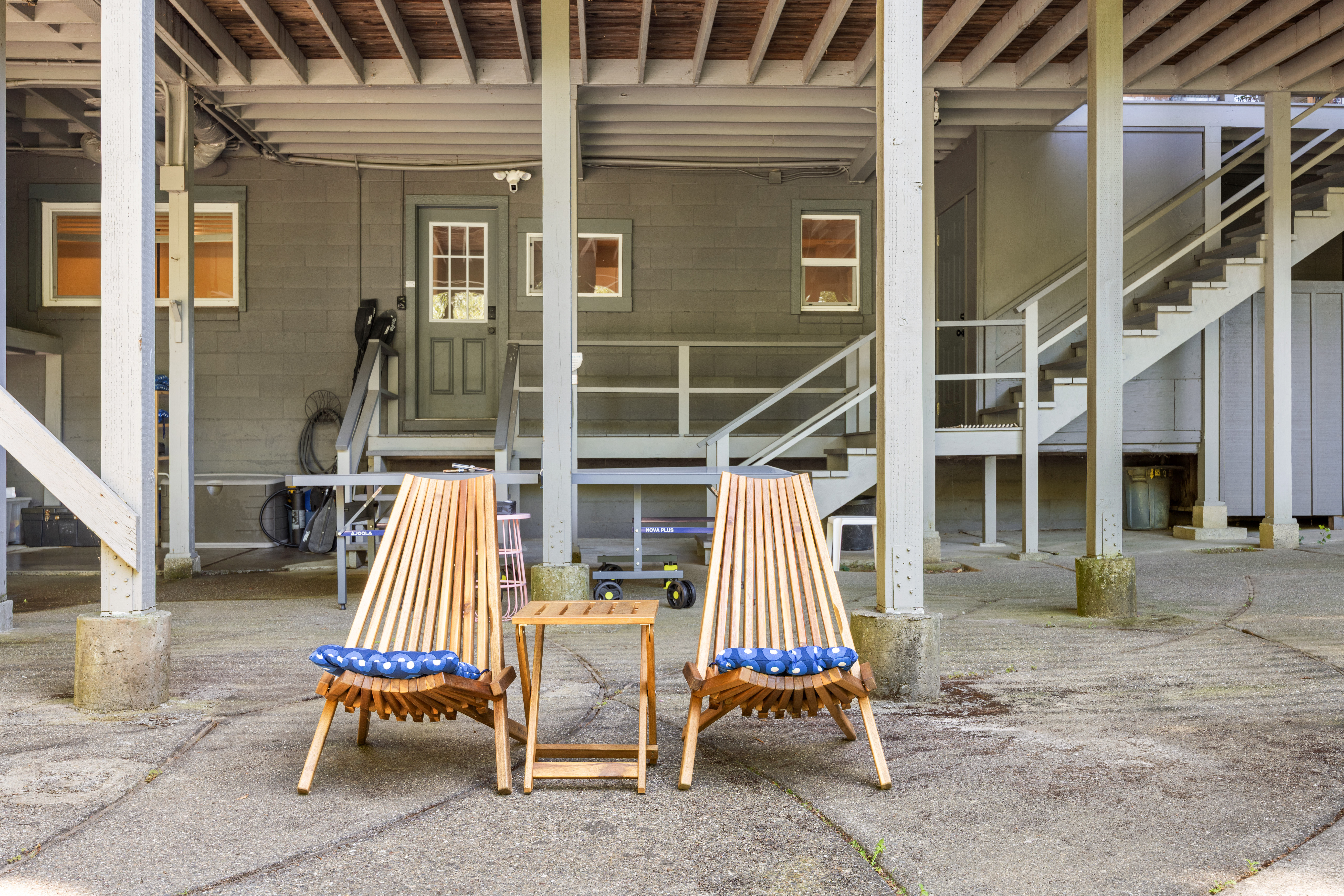 Shaded outdoor lounge space with cozy seating beneath the home