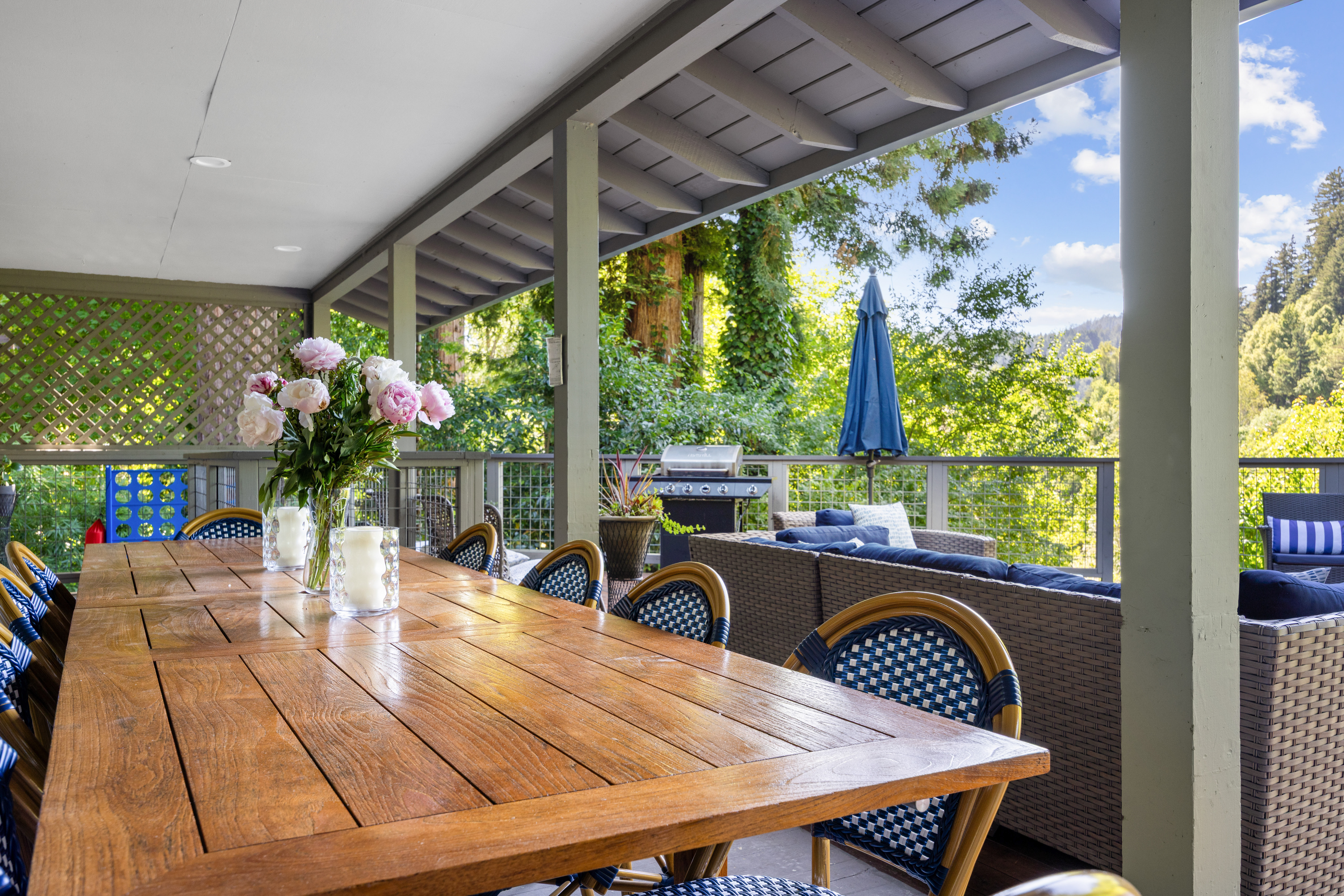 Covered scenic deck with outdoor dining, lounge seating, and grill