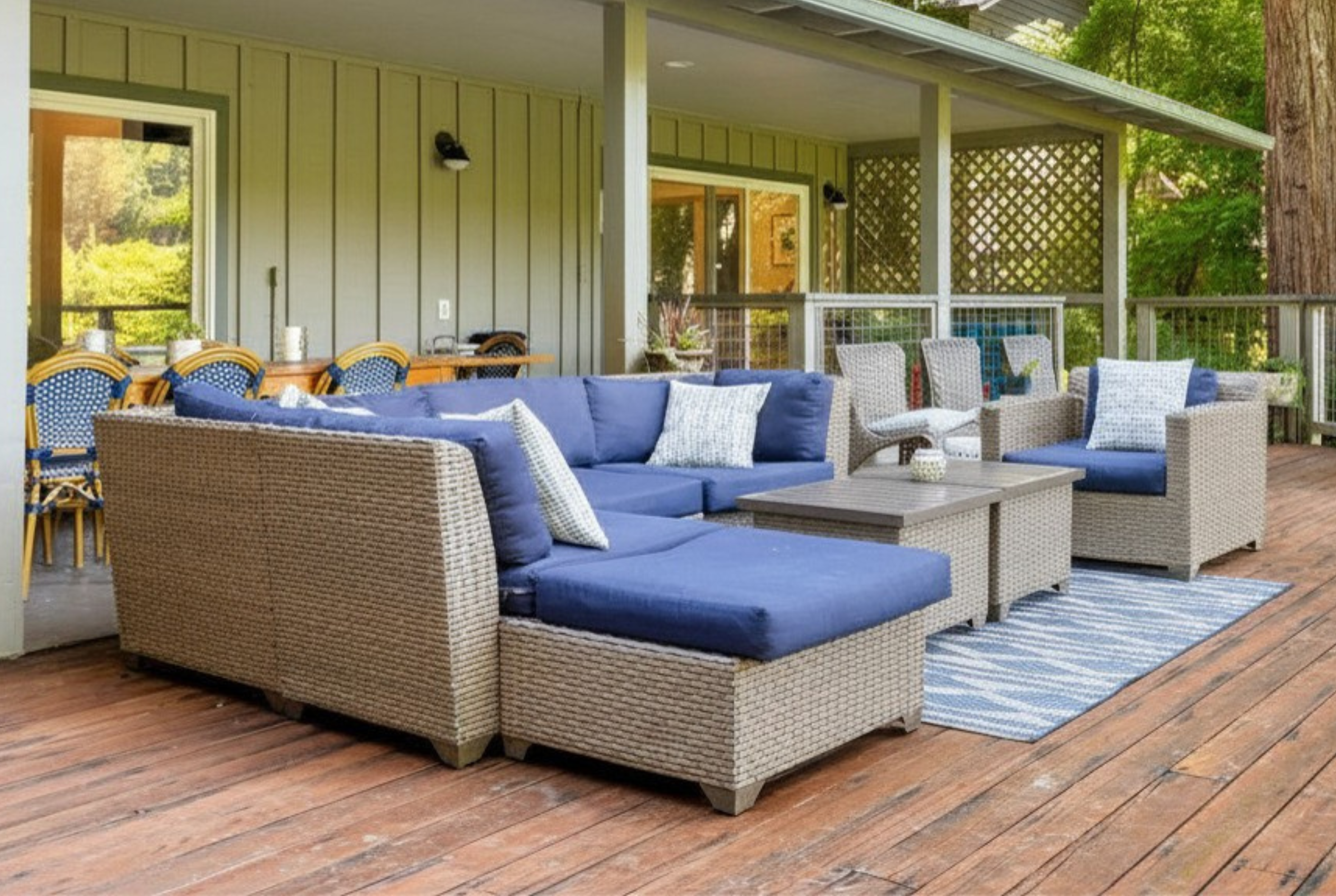 Spacious covered deck with stylish lounge seating and forest views
