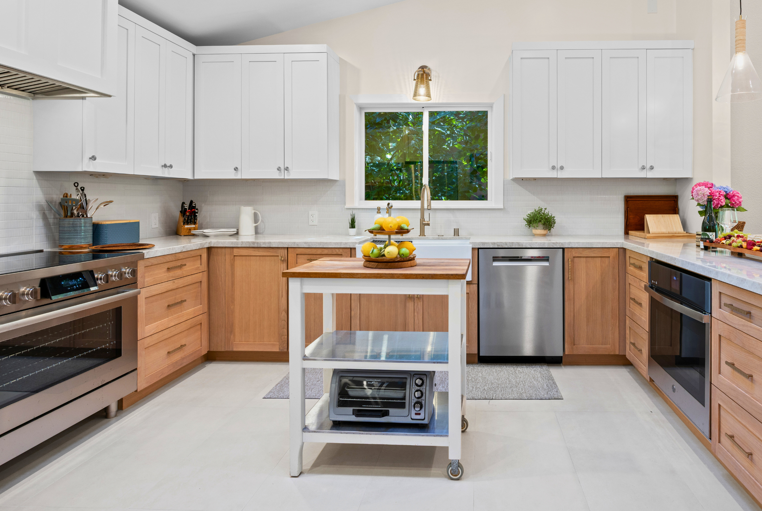 Bright modern kitchen with stainless appliances and charming island cart