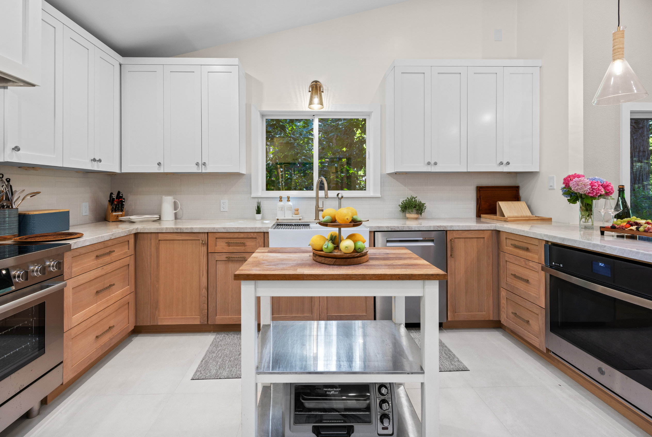 Bright modern kitchen with prep island, stainless appliances, and garden views
