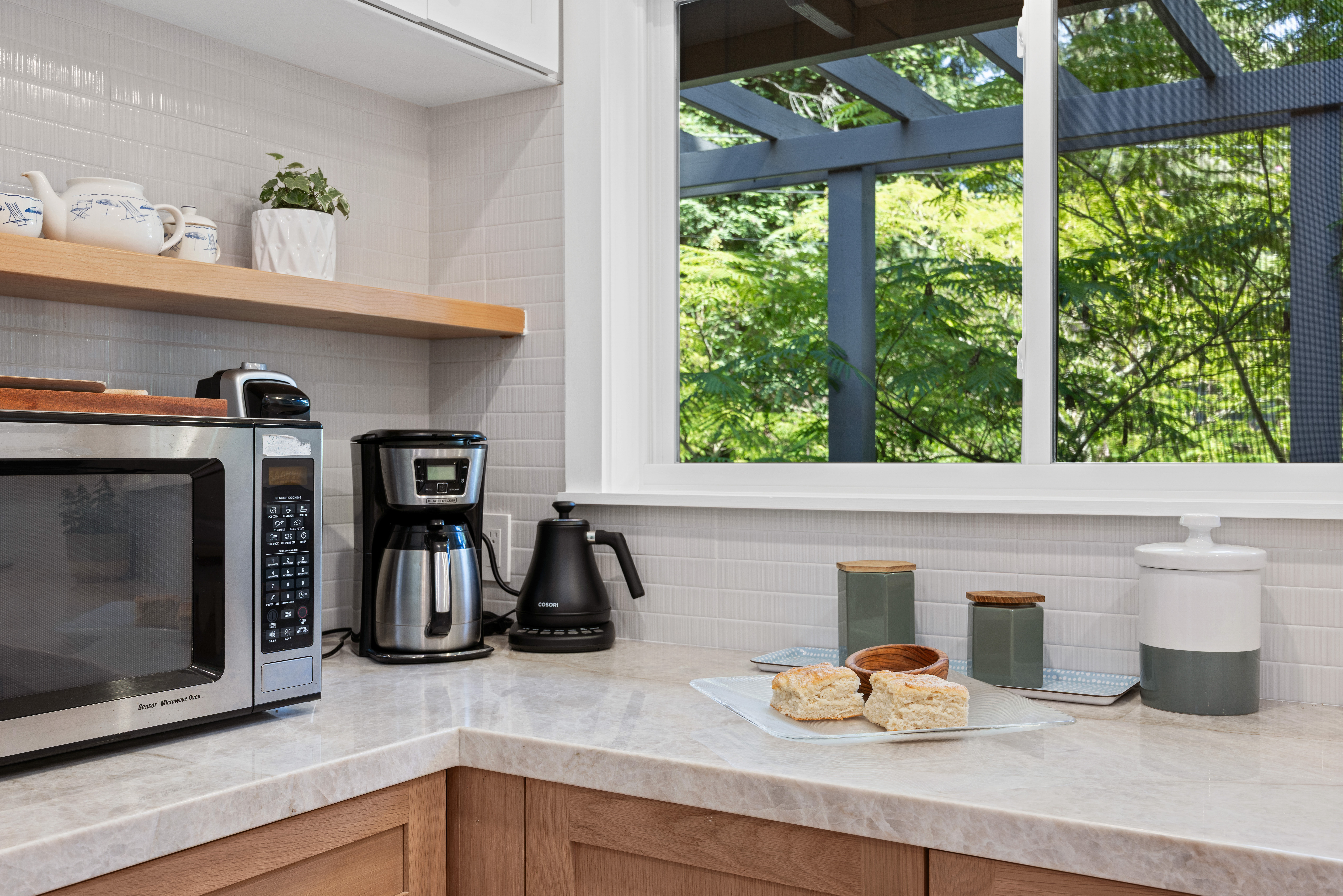 Bright kitchen nook with coffee station and peaceful leafy views