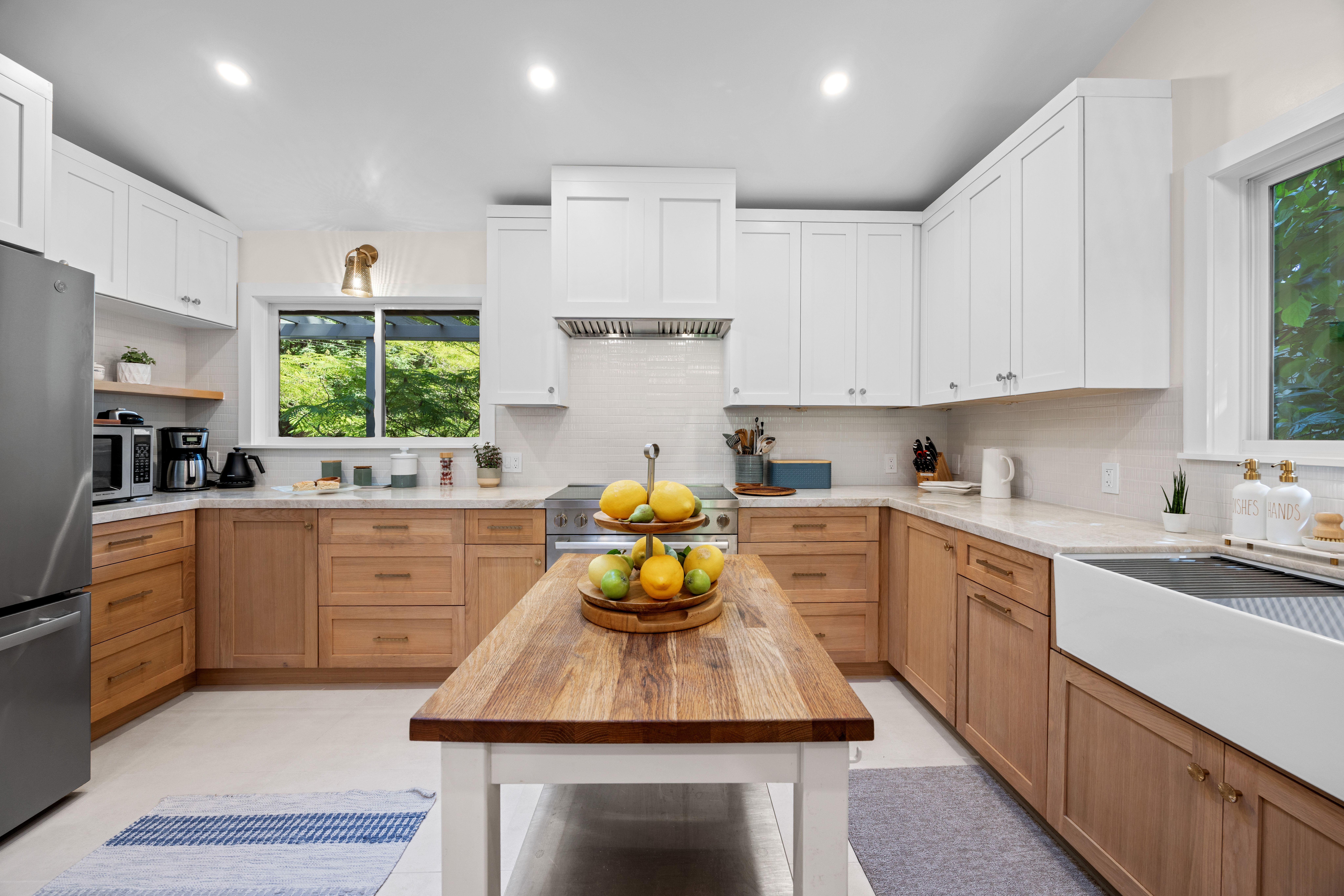 Bright designer kitchen with farmhouse sink and butcher-block island