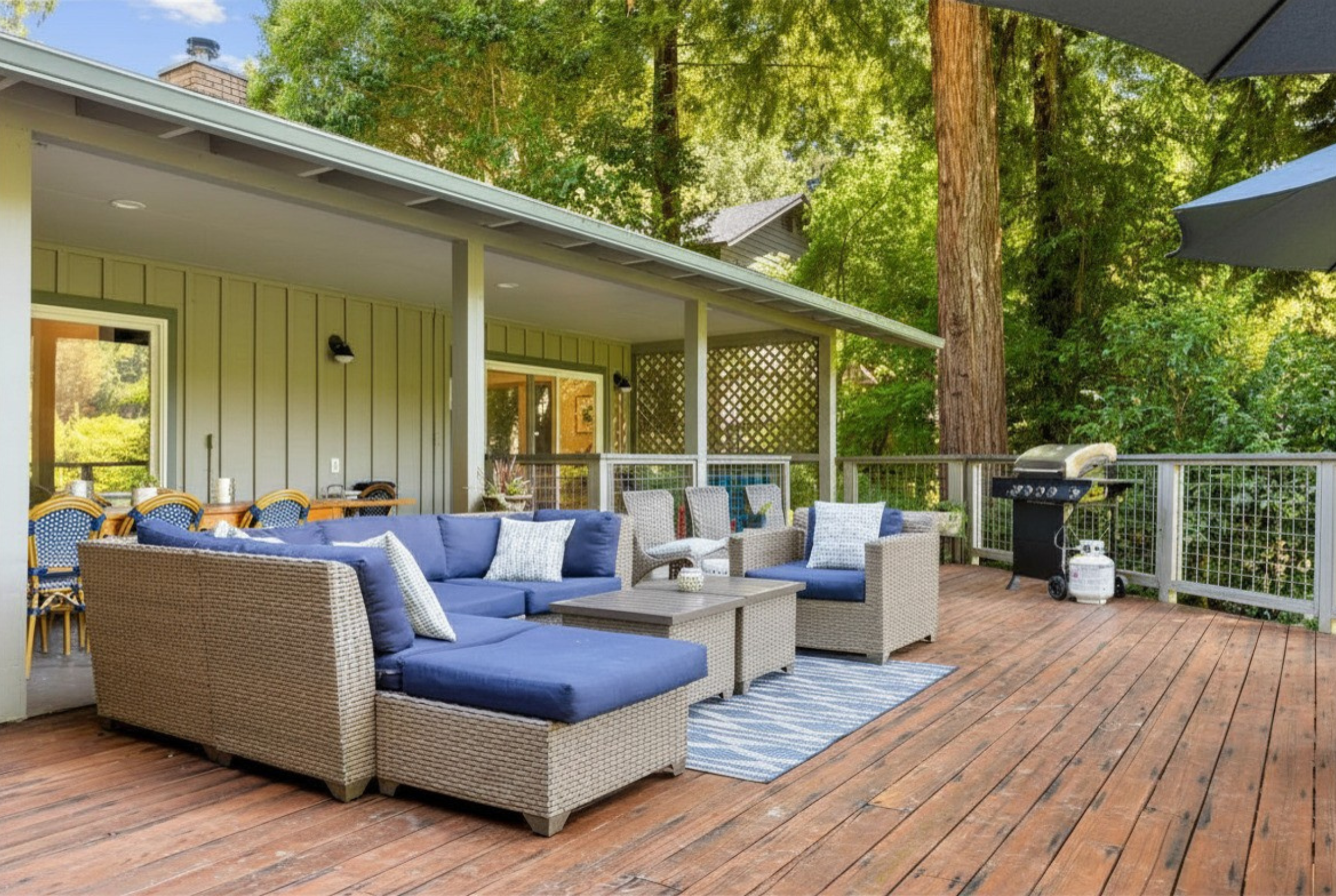 Spacious wooded deck with lounge seating, dining area, and grill