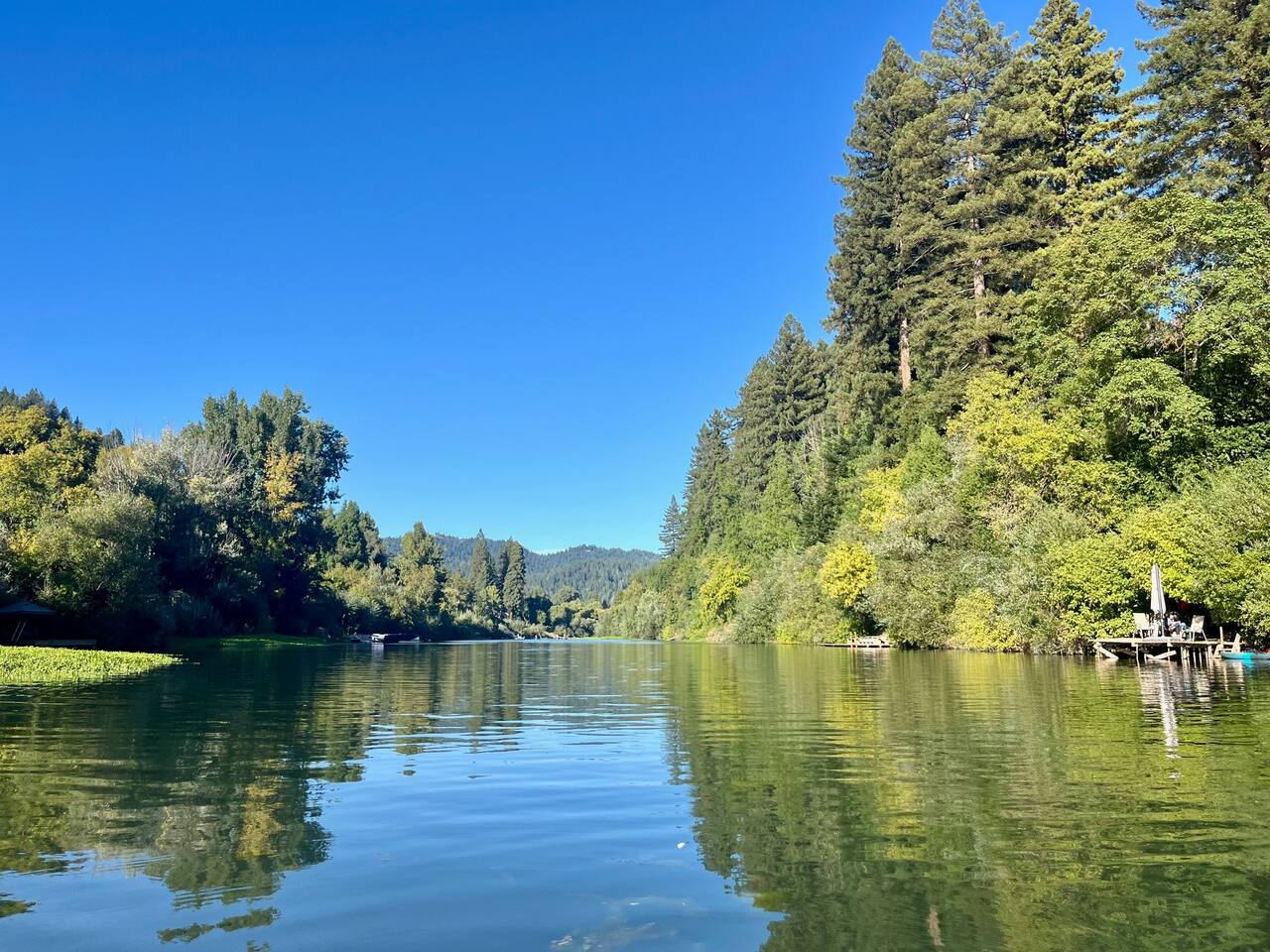 Take in the breathtaking view of the river, gracefully winding through a lush forest, creating a serene and peaceful escape.