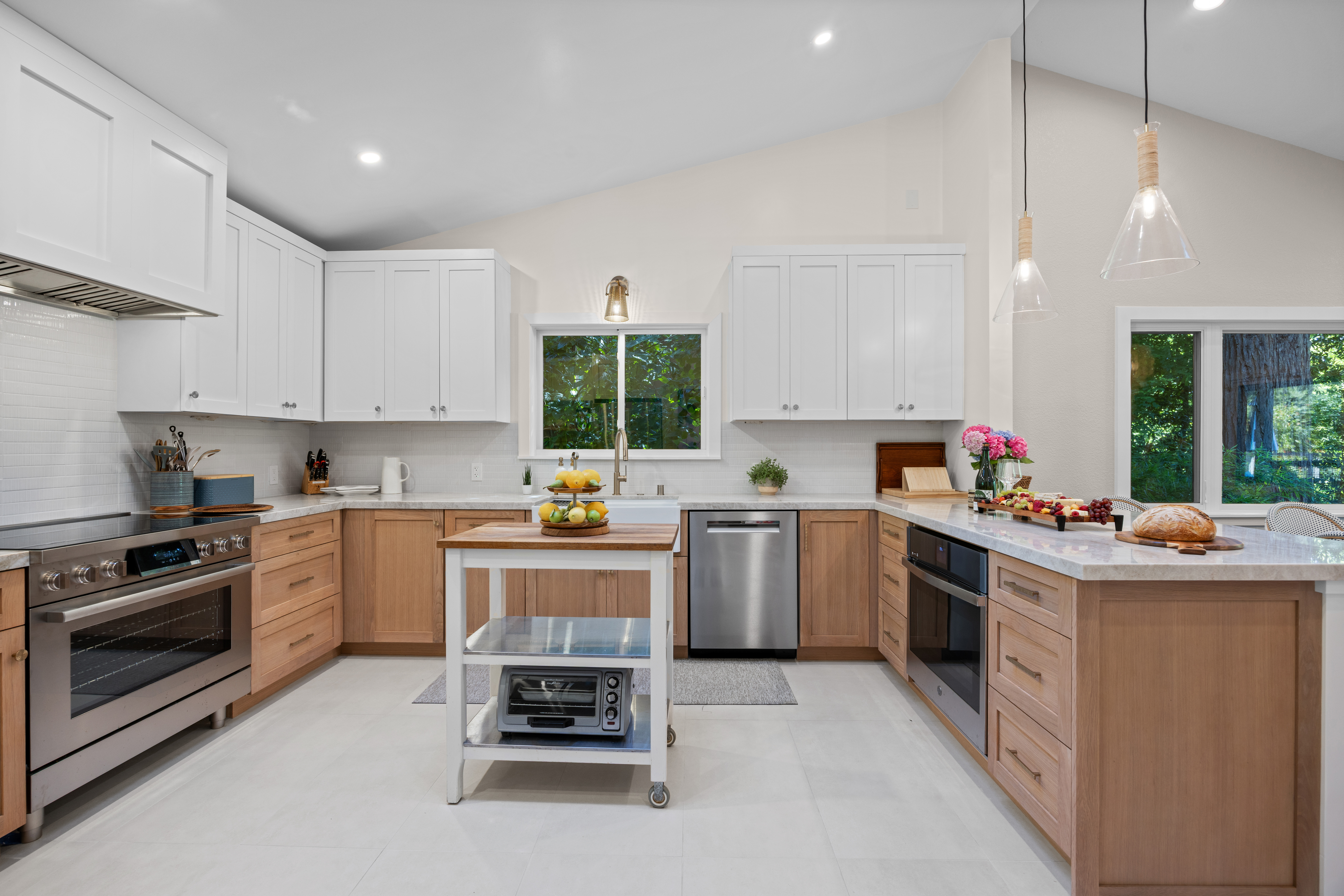 Bright modern kitchen with island, stainless appliances, and garden views