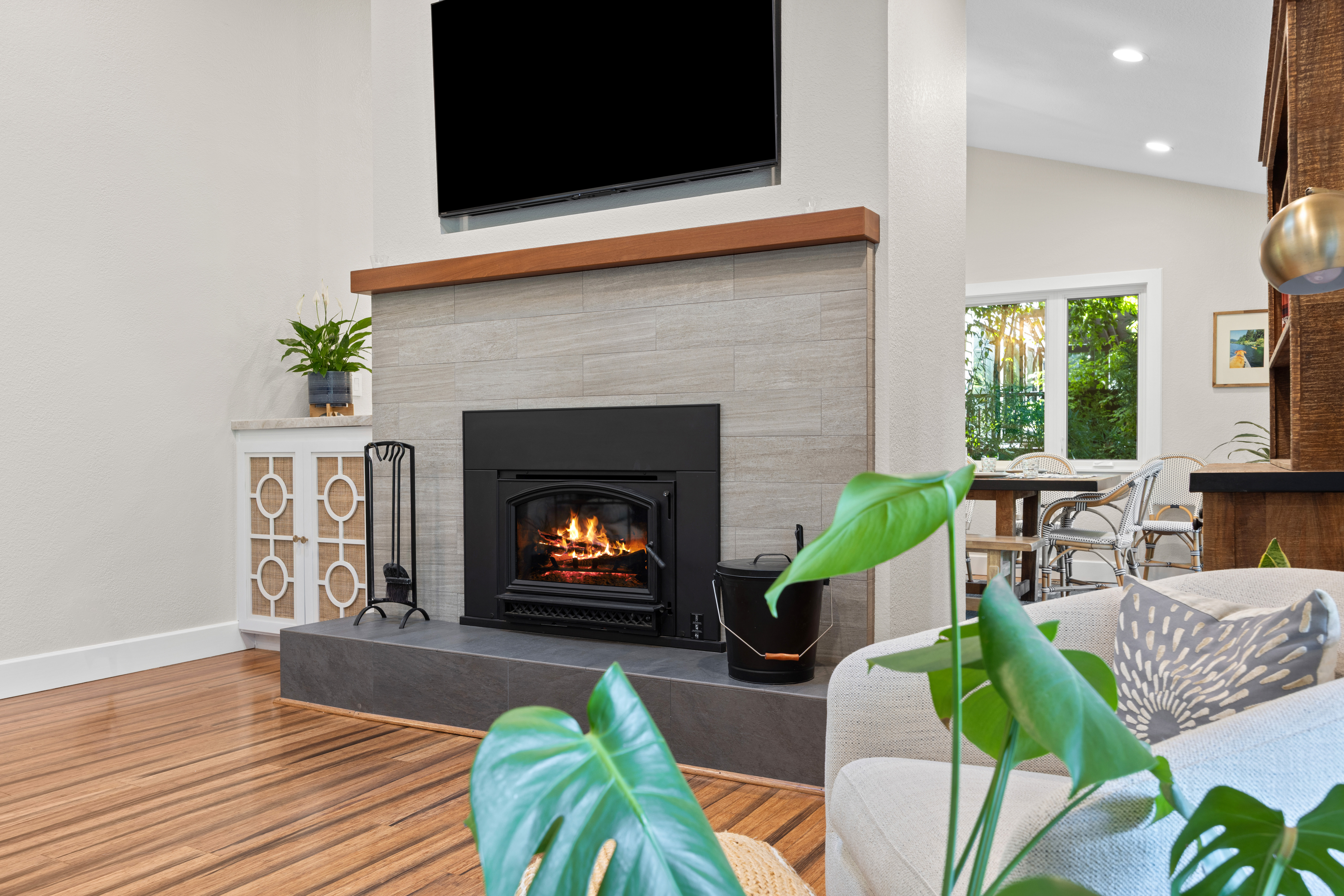 Cozy modern living room with fireplace, TV, and bright garden views