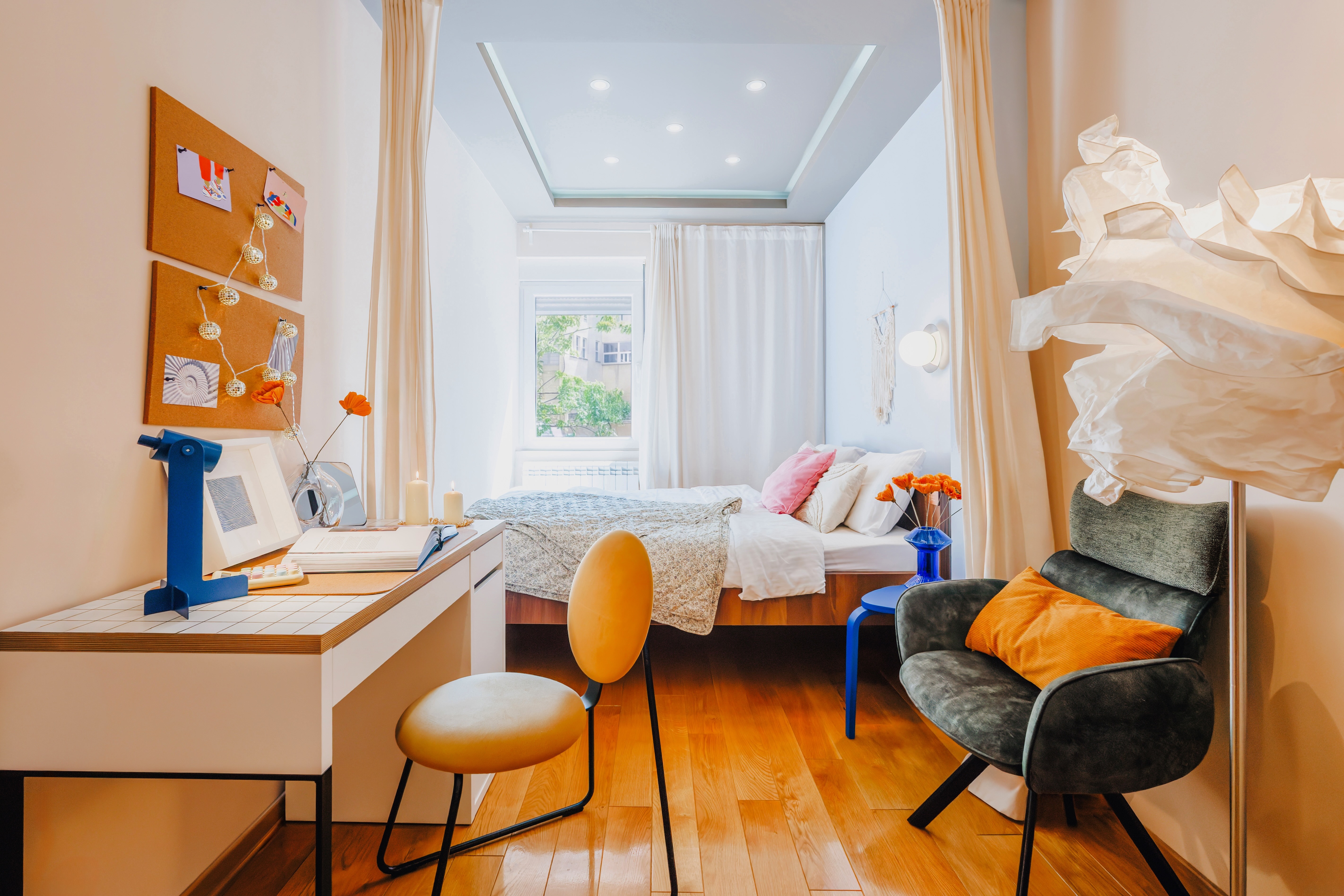 Bright boutique-style bedroom with workspace and cozy seating