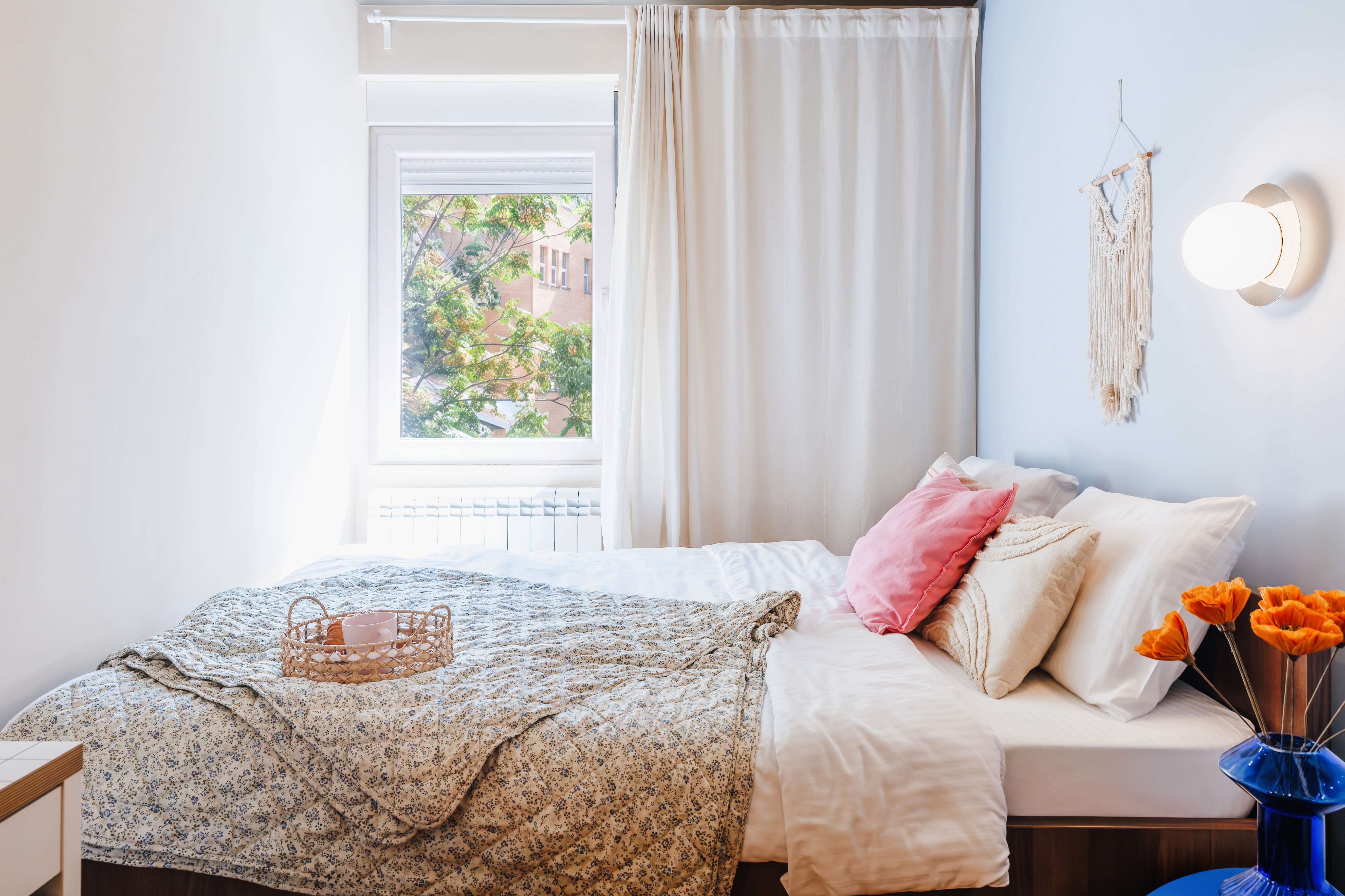 Bright, cozy bedroom with soft linens, natural light, and charming decor