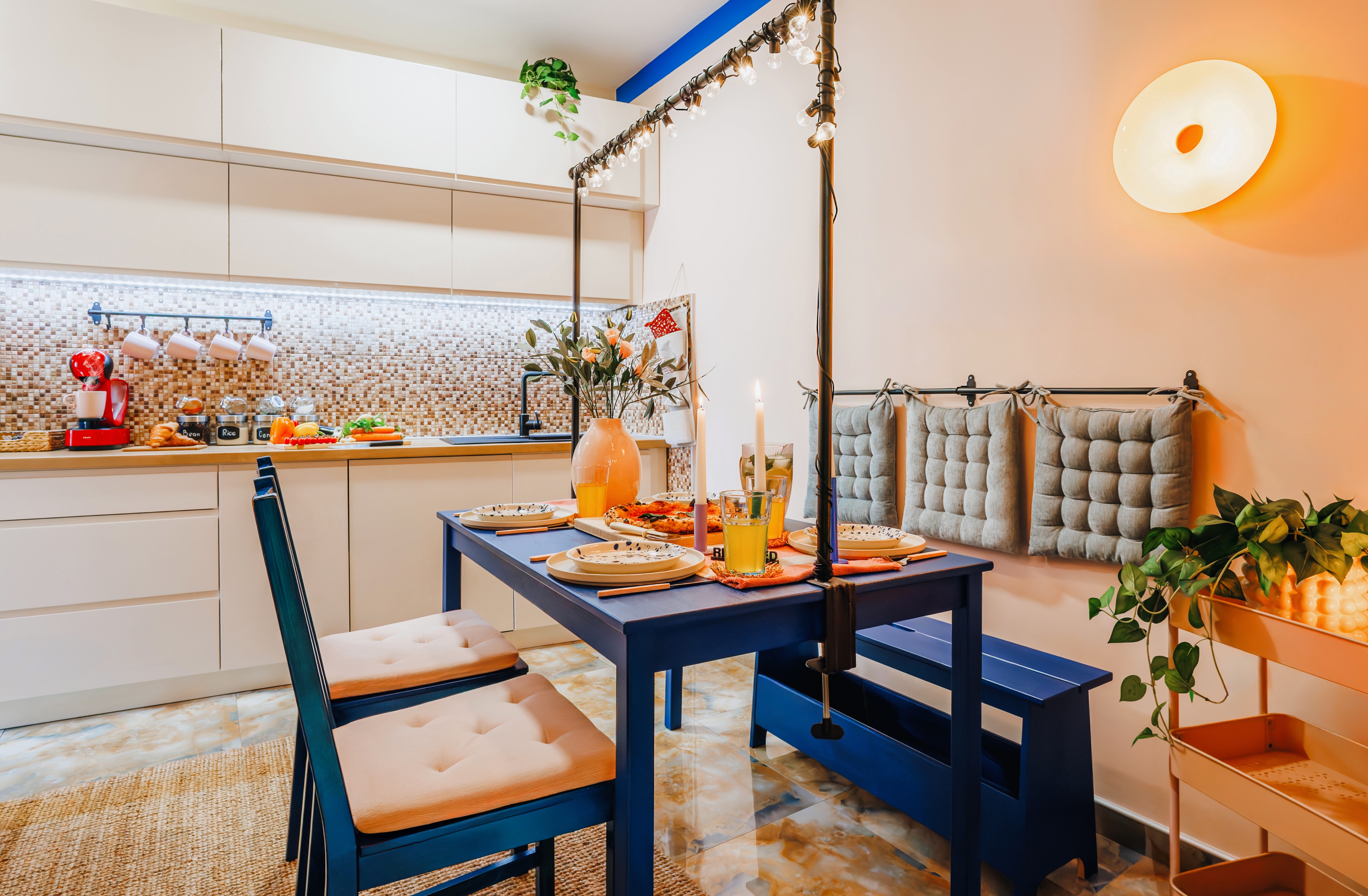 Cozy designer dining nook beside a sleek, fully equipped modern kitchen