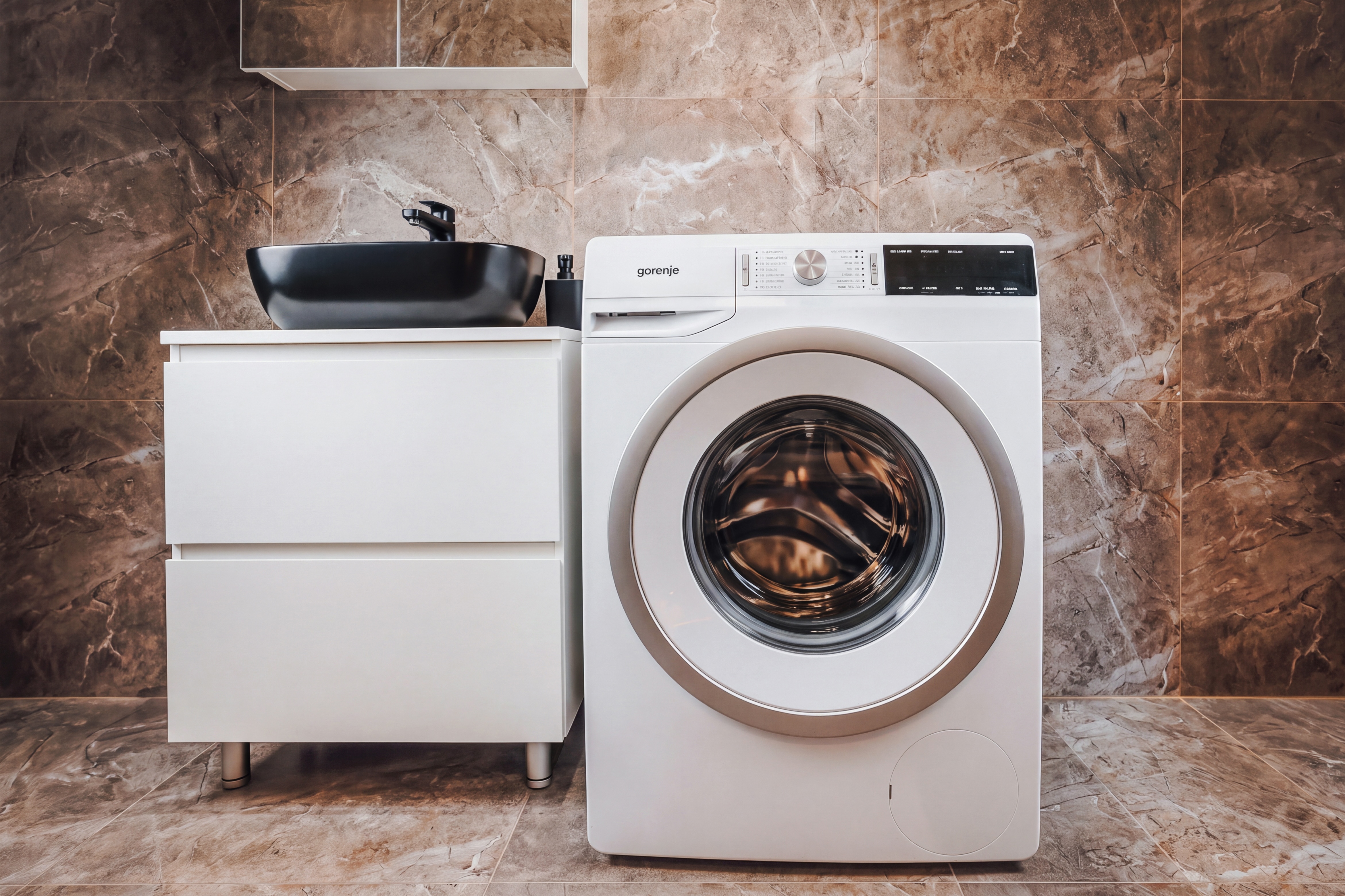 Modern laundry area with stylish vanity and sleek marble finishes