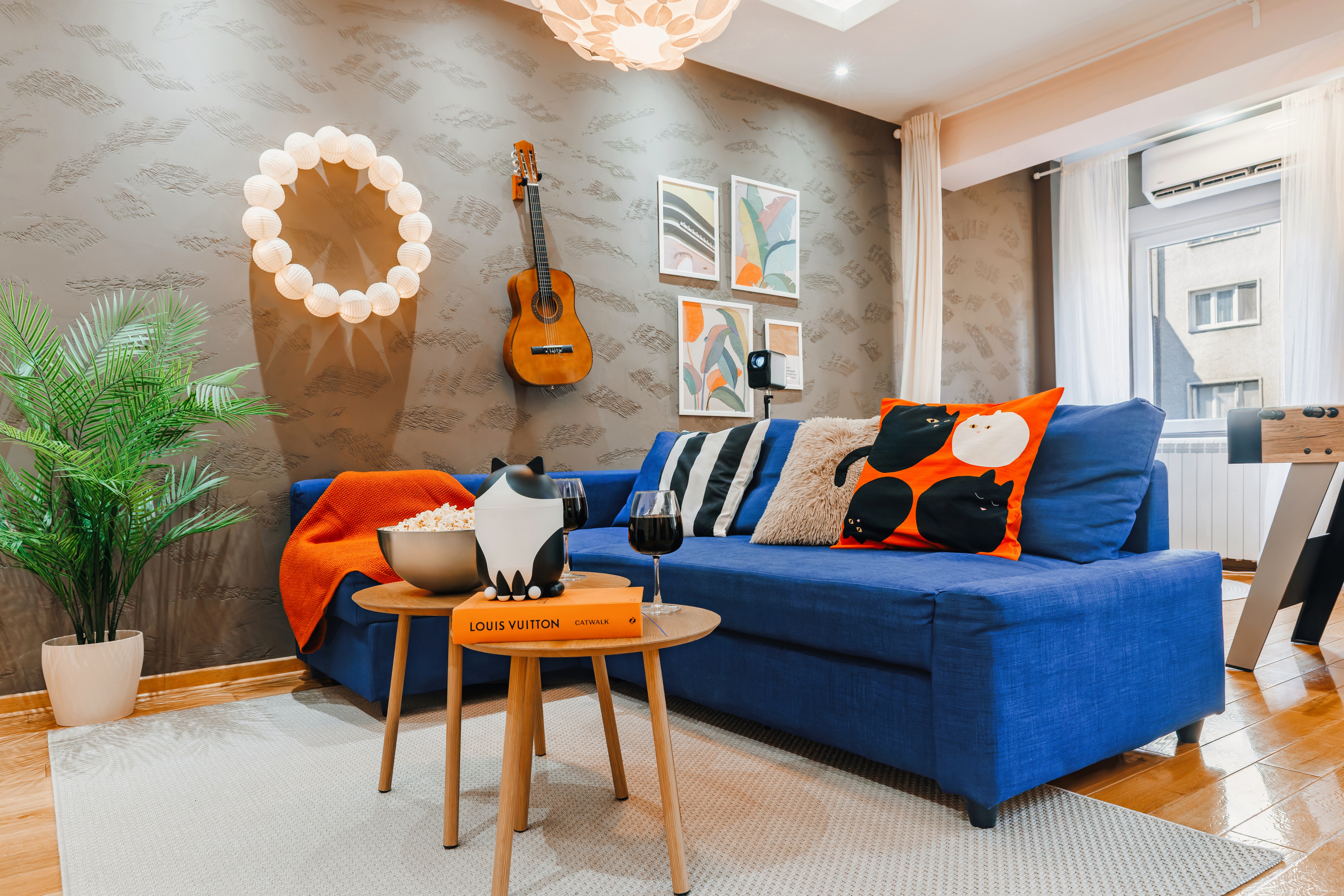 Stylish lounge with bold blue sofa, modern decor, and bright natural light