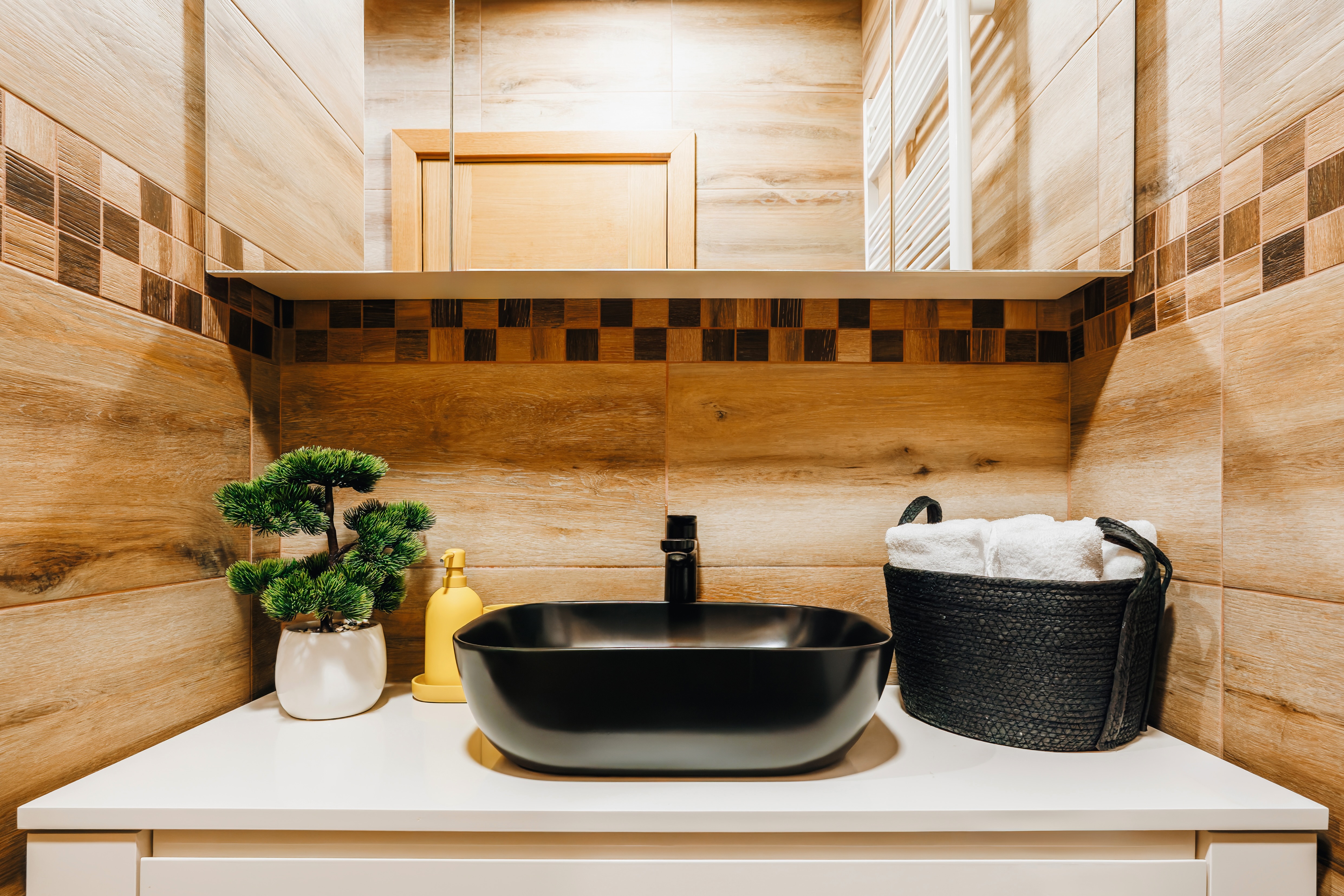 Spa-like bathroom with sleek black sink and warm modern finishes