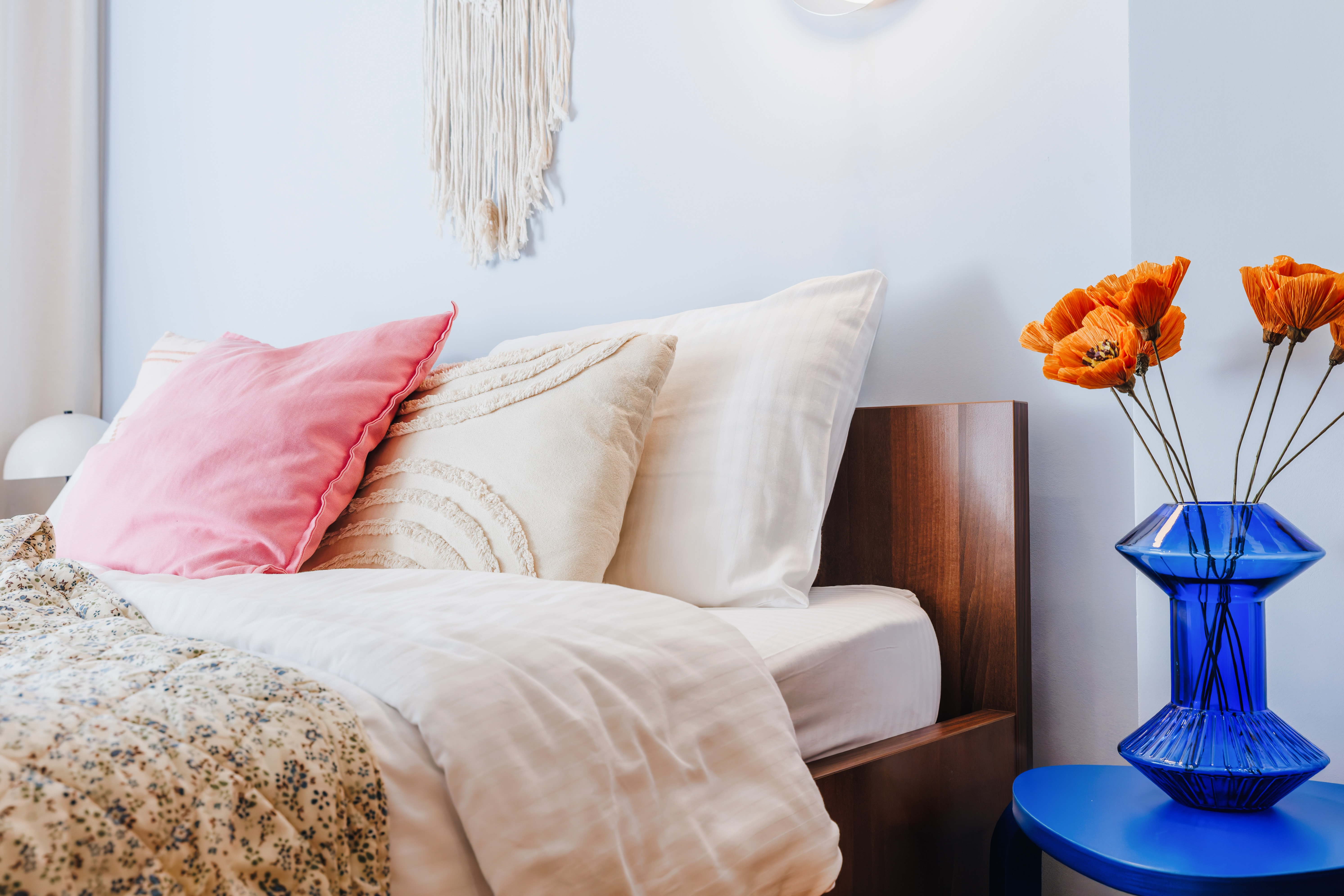 Cozy, design-forward bedroom with warm wood accents and vibrant decor