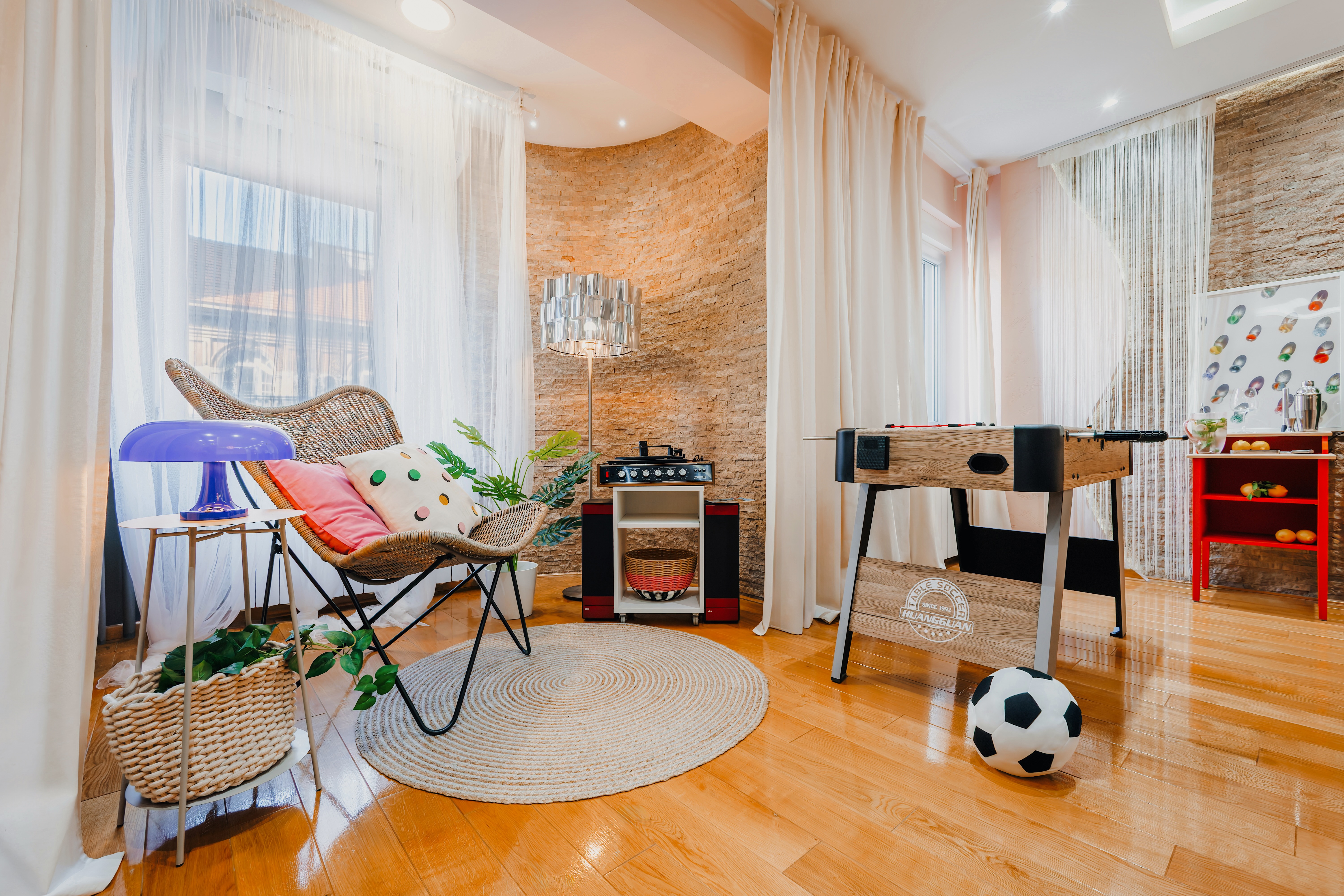 Bright game room with foosball, cozy seating, and playful modern style