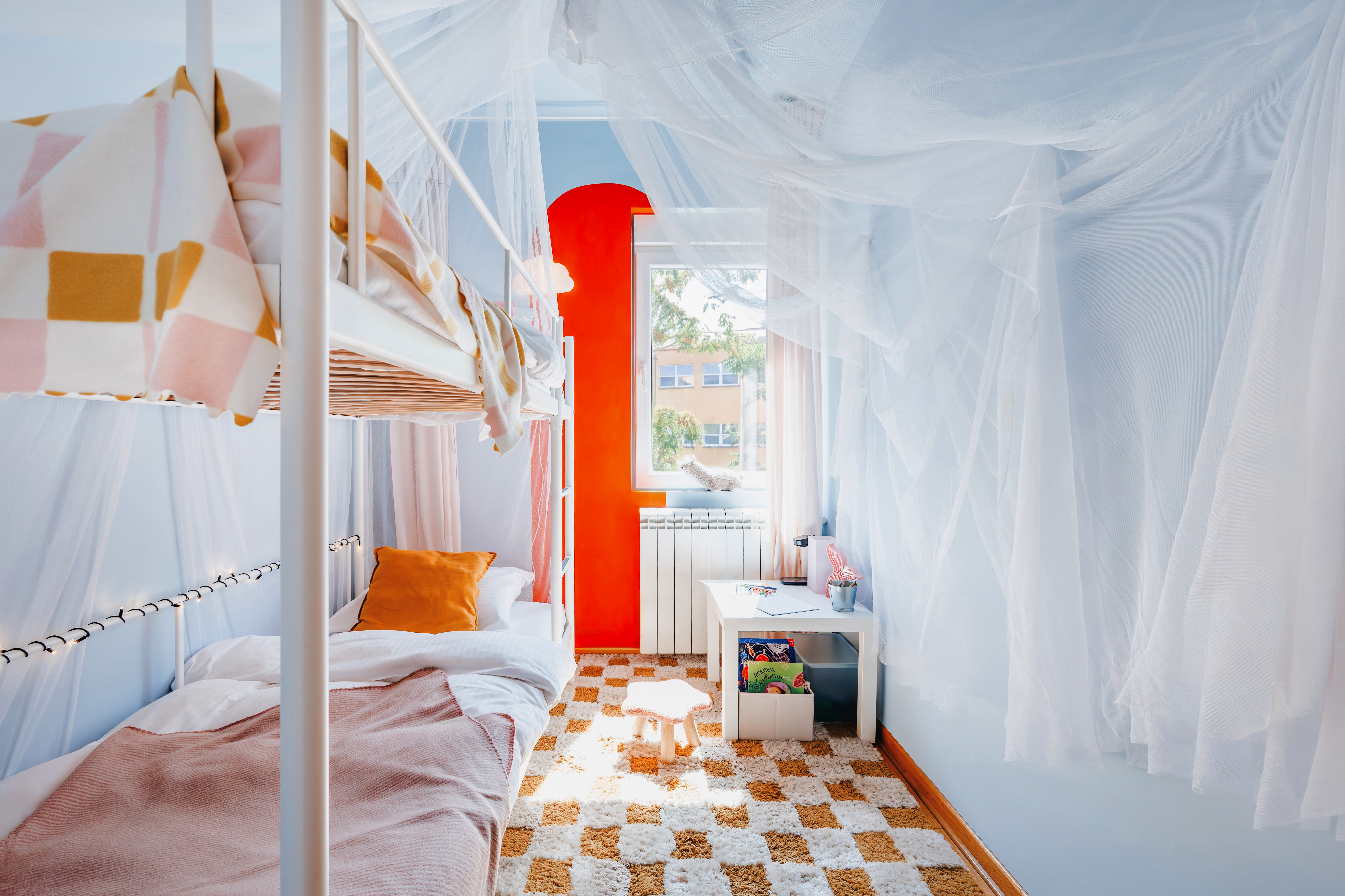 Bright, whimsical bunk room with canopy drapes and playful design