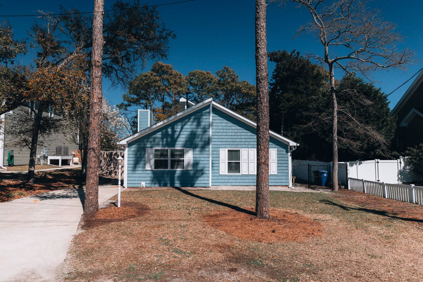 Front elevation with shuttered windows and a fenced side yard