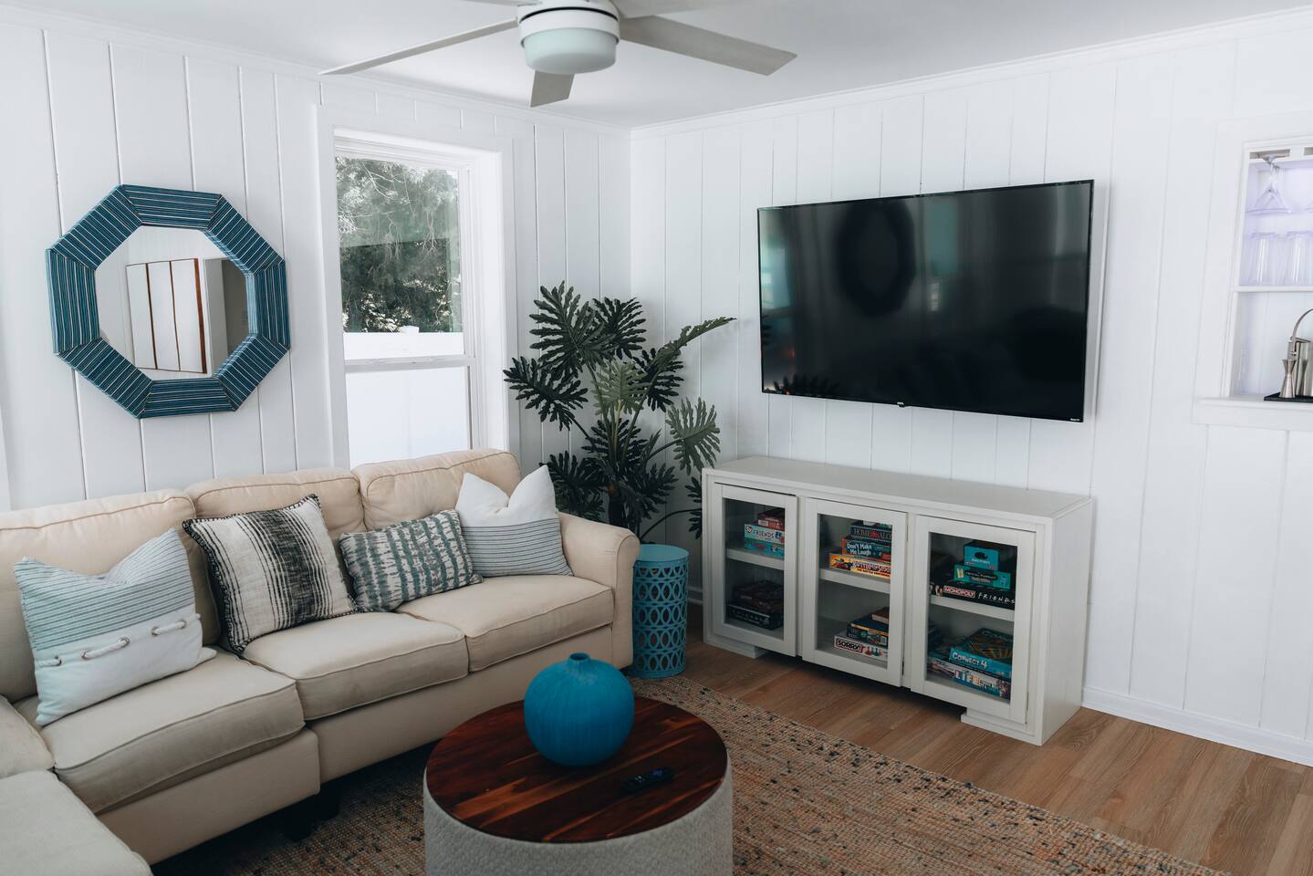 Living room with sectional, mounted TV and a cabinet of board games