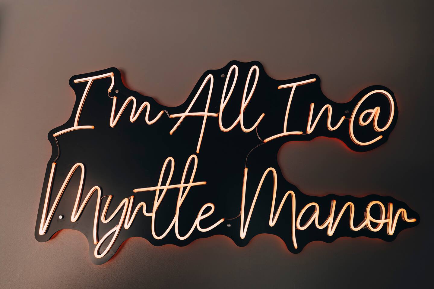 Neon script sign reading I'm All In at Myrtle Manor