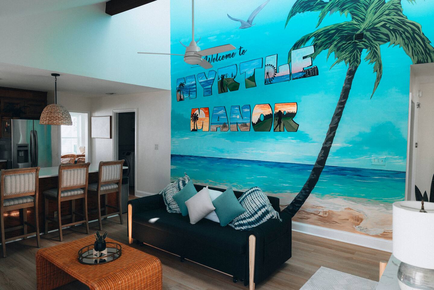 Living area with a sofa bed and a painted Myrtle Manor mural