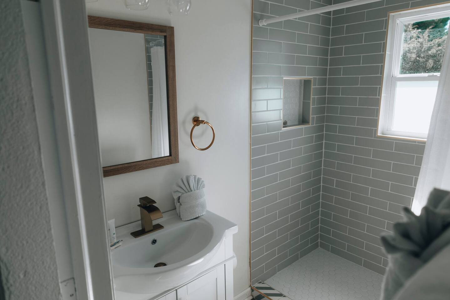 Vanity with brass fixtures, wood-framed mirror and folded towels