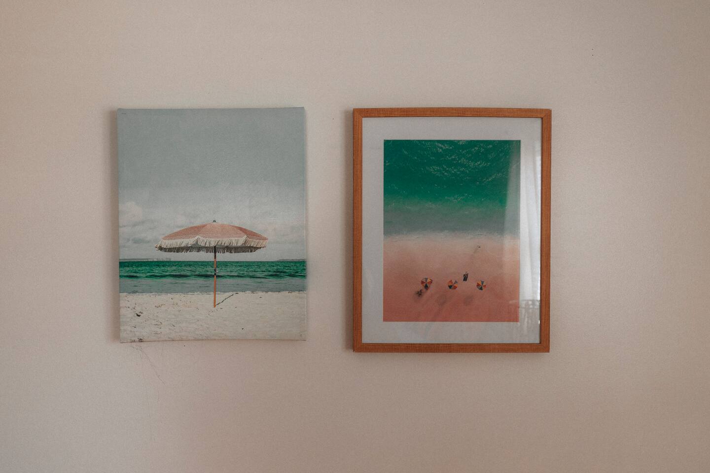 Two beach prints, one framed in wood, hung side by side