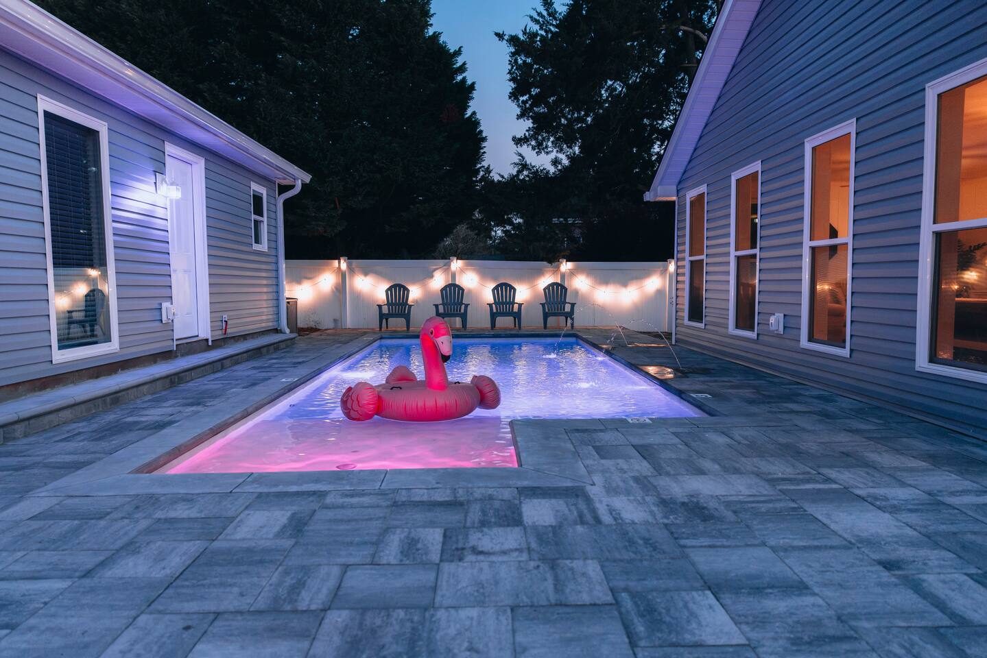 Paved pool deck between the two buildings at nightfall