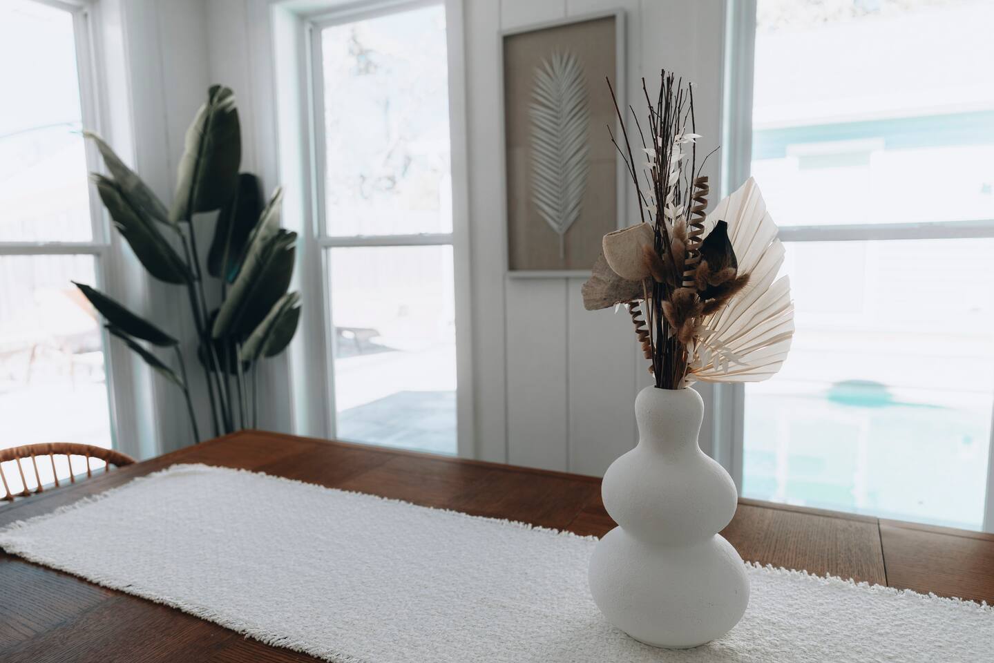 Dining table detail with the pool visible through the windows