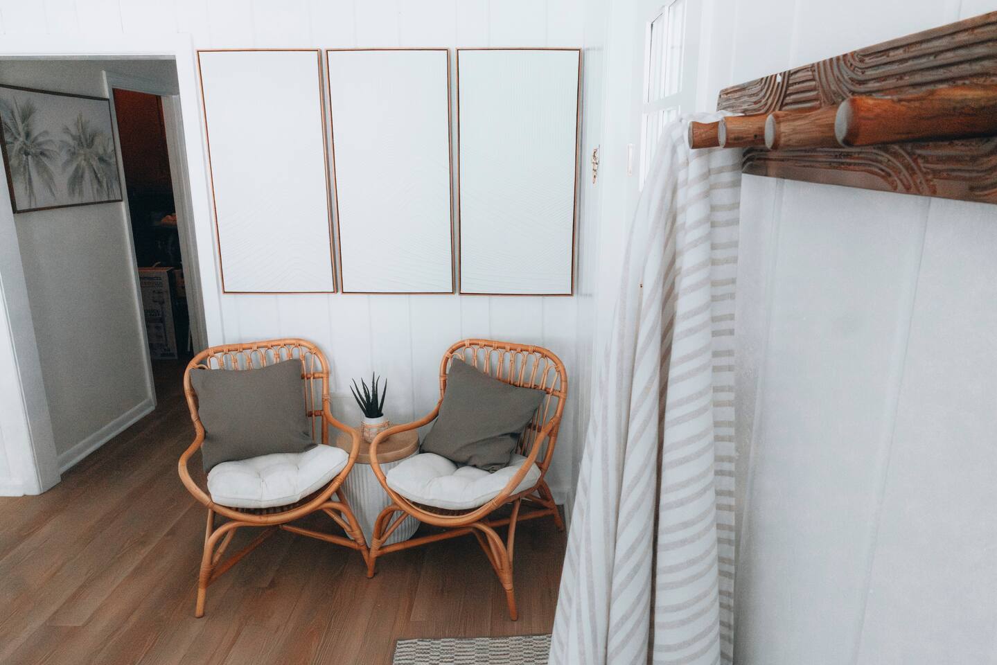 Two rattan chairs and a small side table beside the doorway