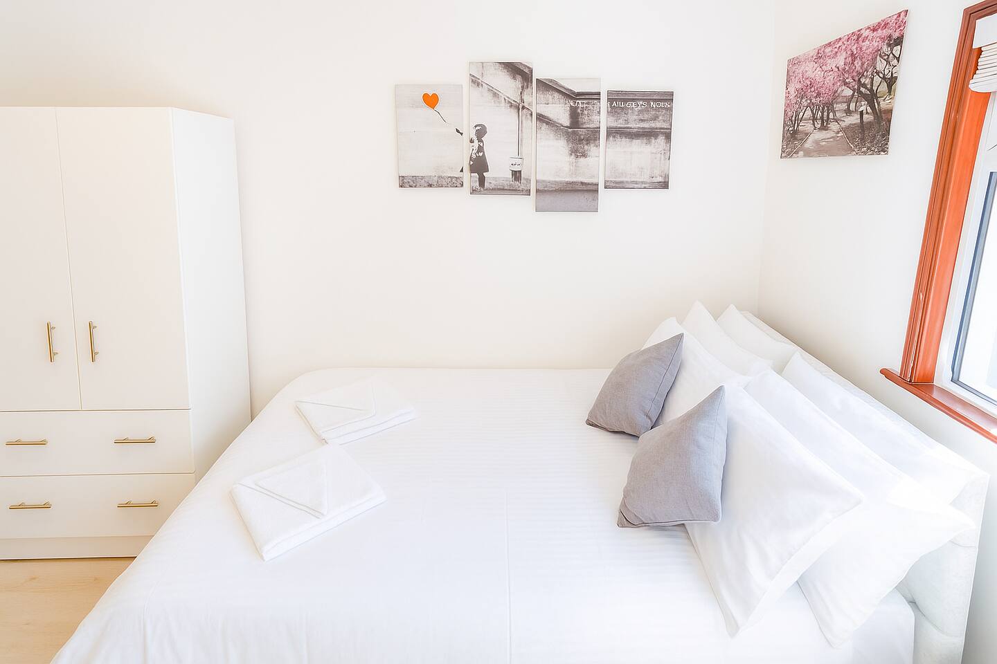 This cozy bedroom in Shephard's Bush, Greater London features a plush white bed, modern wardrobe, and inspiring wall art. Natural light pours in through the window, creating a peaceful retreat perfect for rest and relaxation.