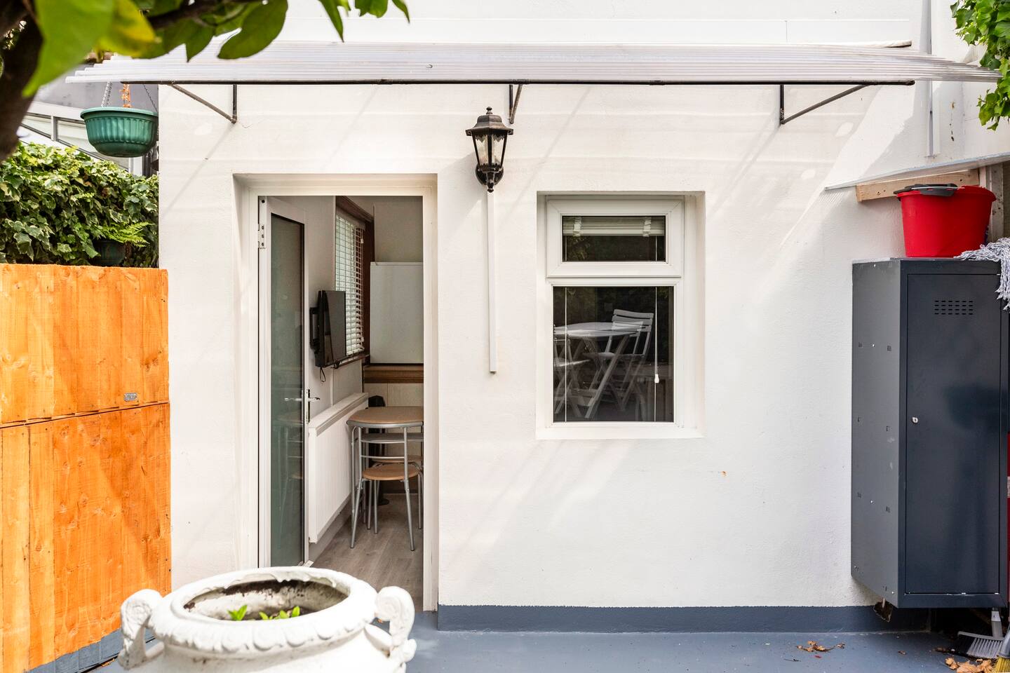 Cozy outdoor entry with seating, greenery, and soft natural light.