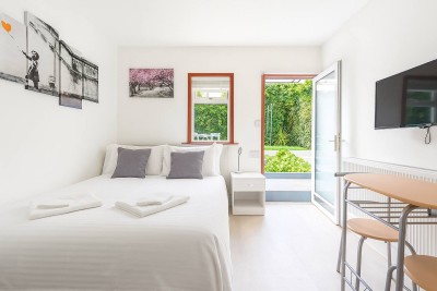 Bright, minimalist room in Shepherd’s Bush with cozy bed, garden views, curated wall art and private desk. Just minutes from Hammersmith, with direct access to lush outdoor space for work or rest.