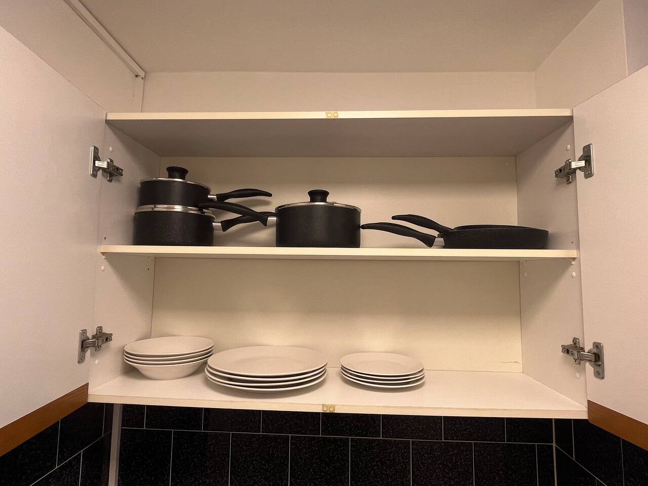 Simple kitchen with a gas cooktop, washer, and black tile backsplash.