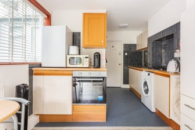 Compact kitchen in Shepherd’s Bush with built-in gas stove, washing machine and tiled backsplash. Just minutes from Hammersmith, it’s a stylish, practical space for everyday cooking in West London.