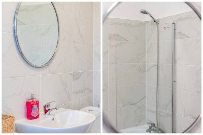 Sleek bathroom with modern sink, round mirror, and glass shower.