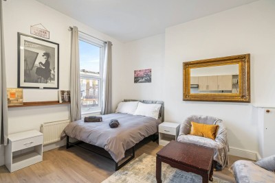 Stylish lounge in Shepherd’s Bush with cozy armchair, sleek desk, city views and gold accents. Just moments from Notting Hill, it offers a modern, tranquil vibe in West London’s vibrant heart.