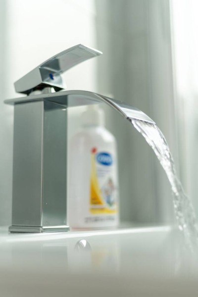 Sleek faucet with soft water flow and gentle lighting for fresh feel.